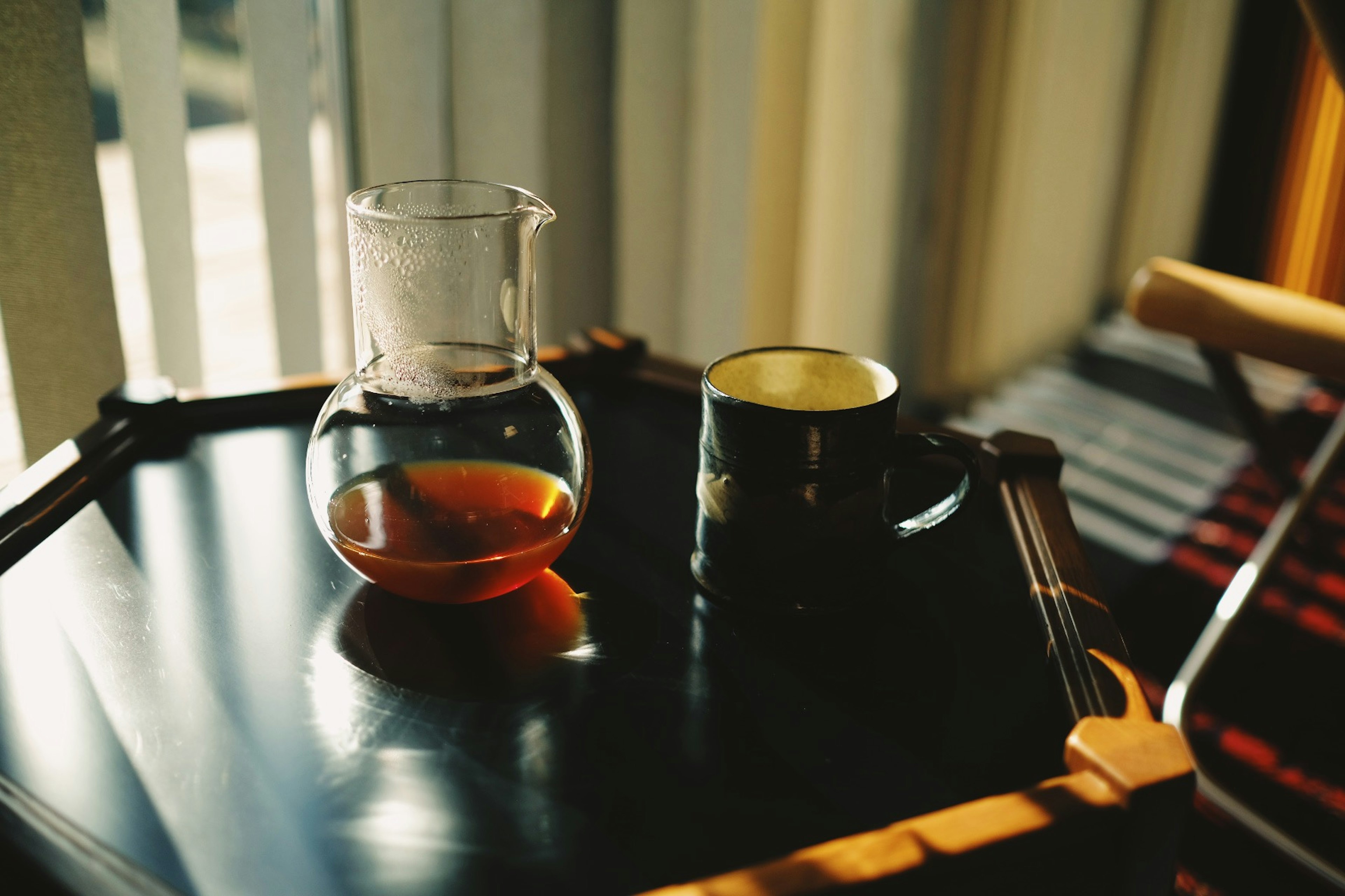 Tetera de vidrio y taza sobre una mesa de madera