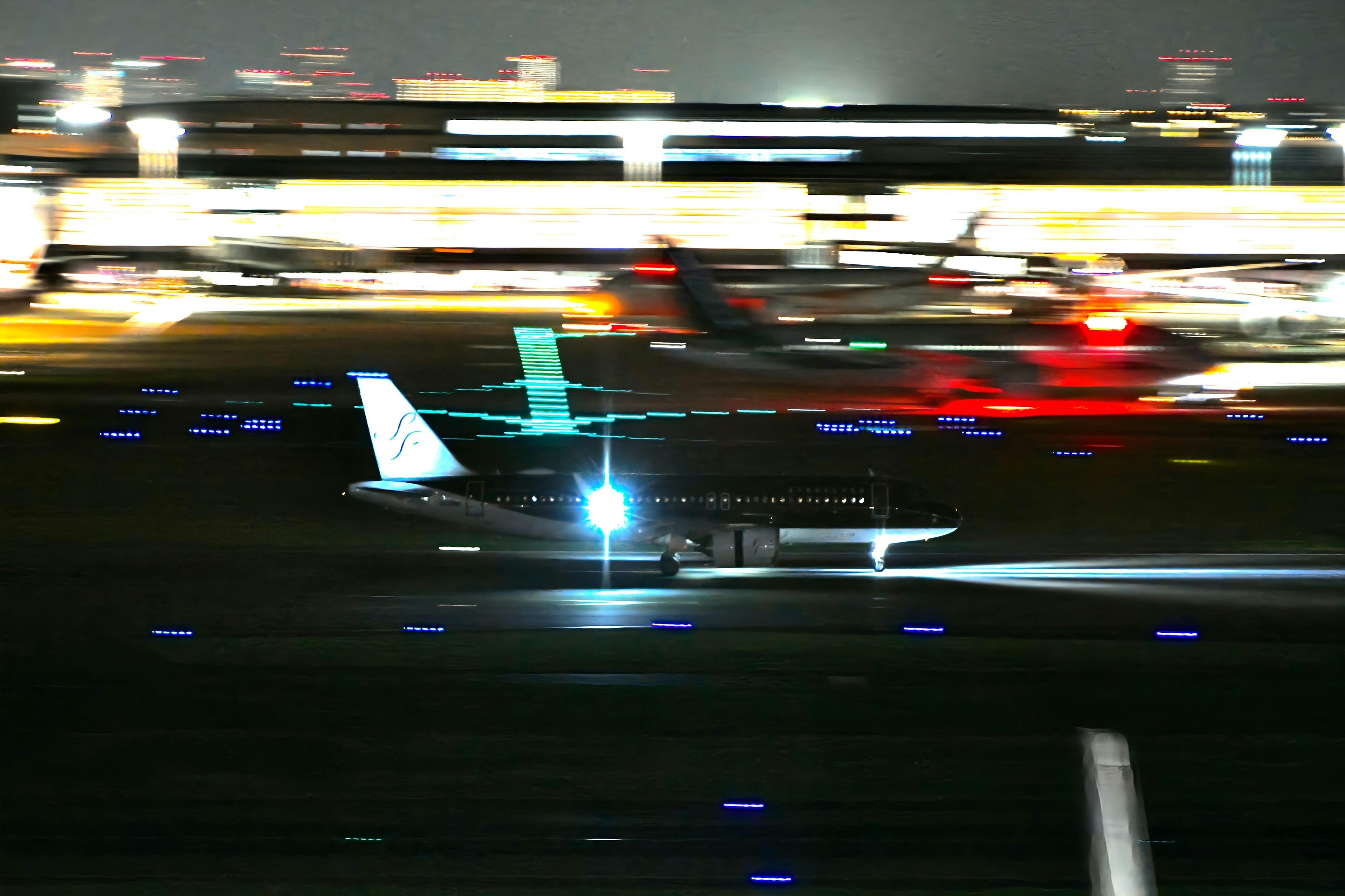 Ein Flugzeug, das nachts auf einer Landebahn mit hellen Lichtern rollt