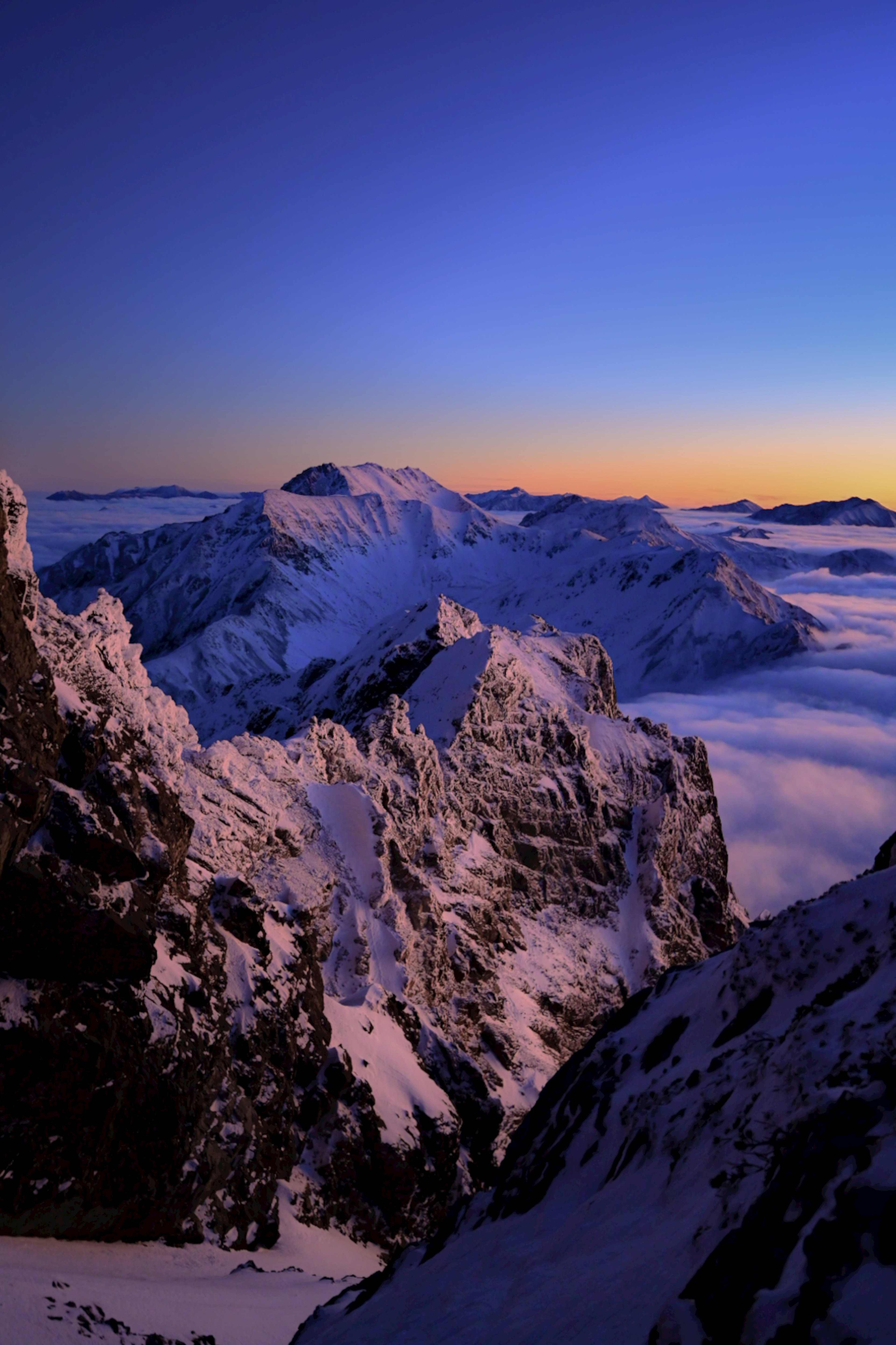 Vue magnifique des montagnes enneigées et d'une mer de nuages