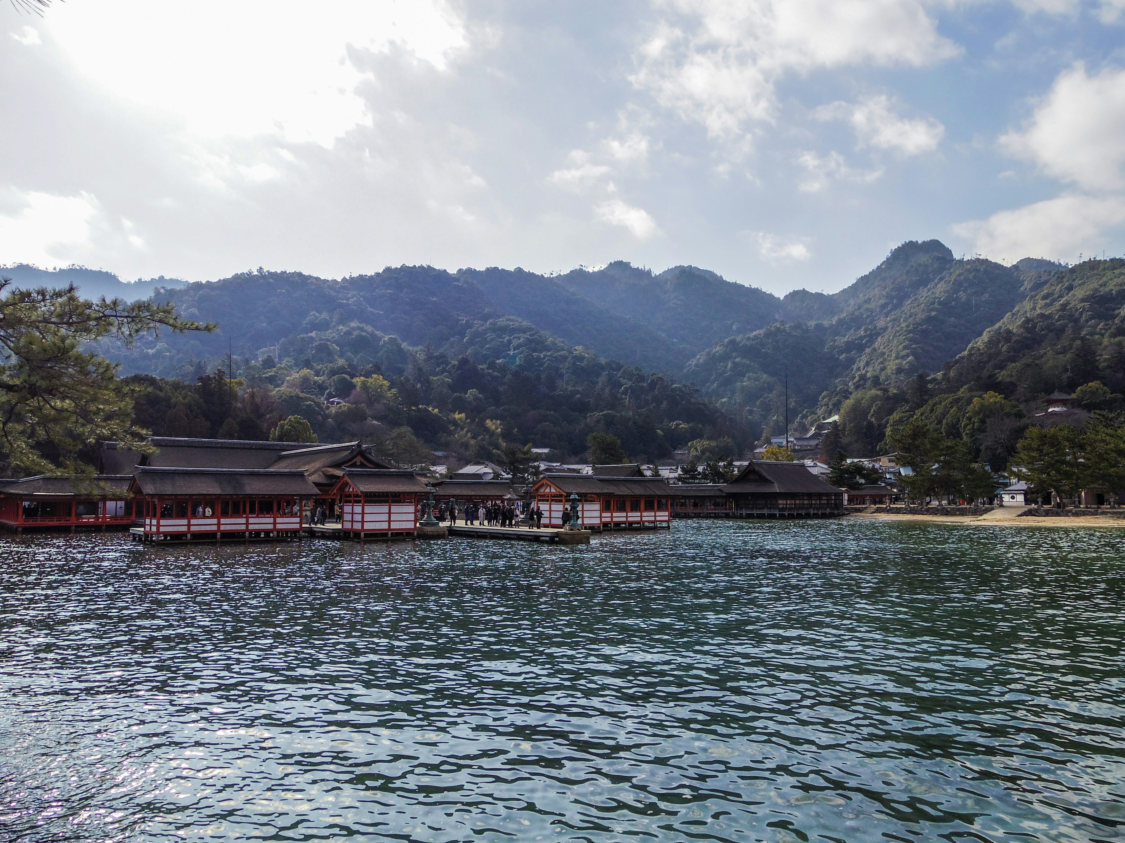 Traditional Japanese buildings surrounded by calm sea and mountains