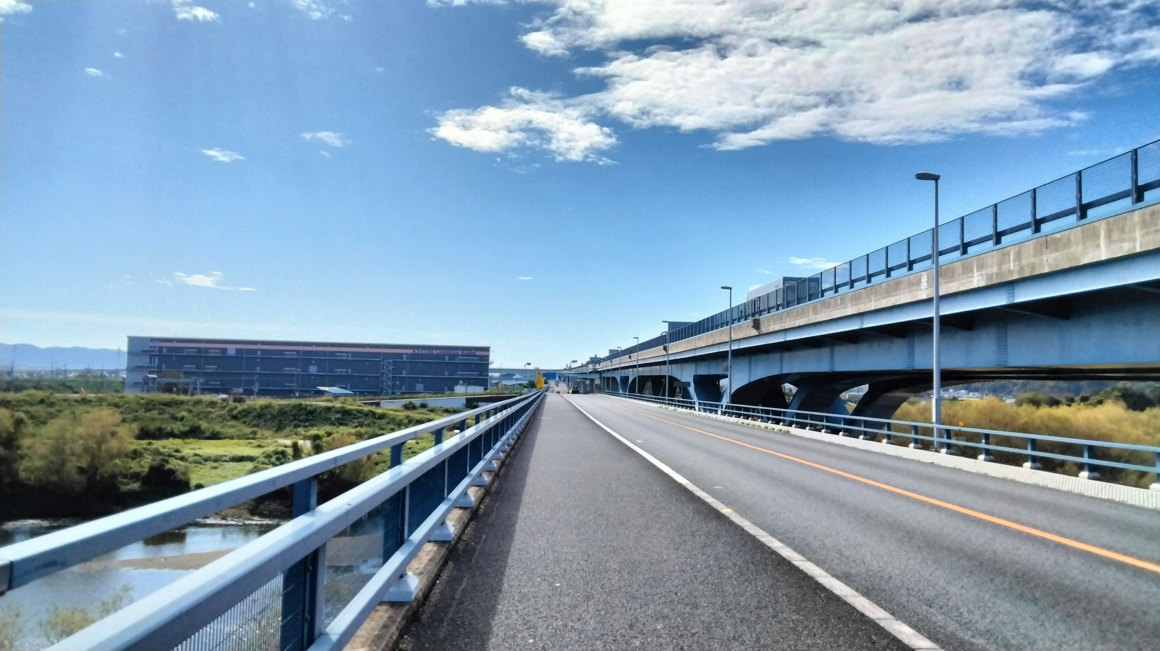 Vista de una carretera abierta y un puente bajo un cielo azul