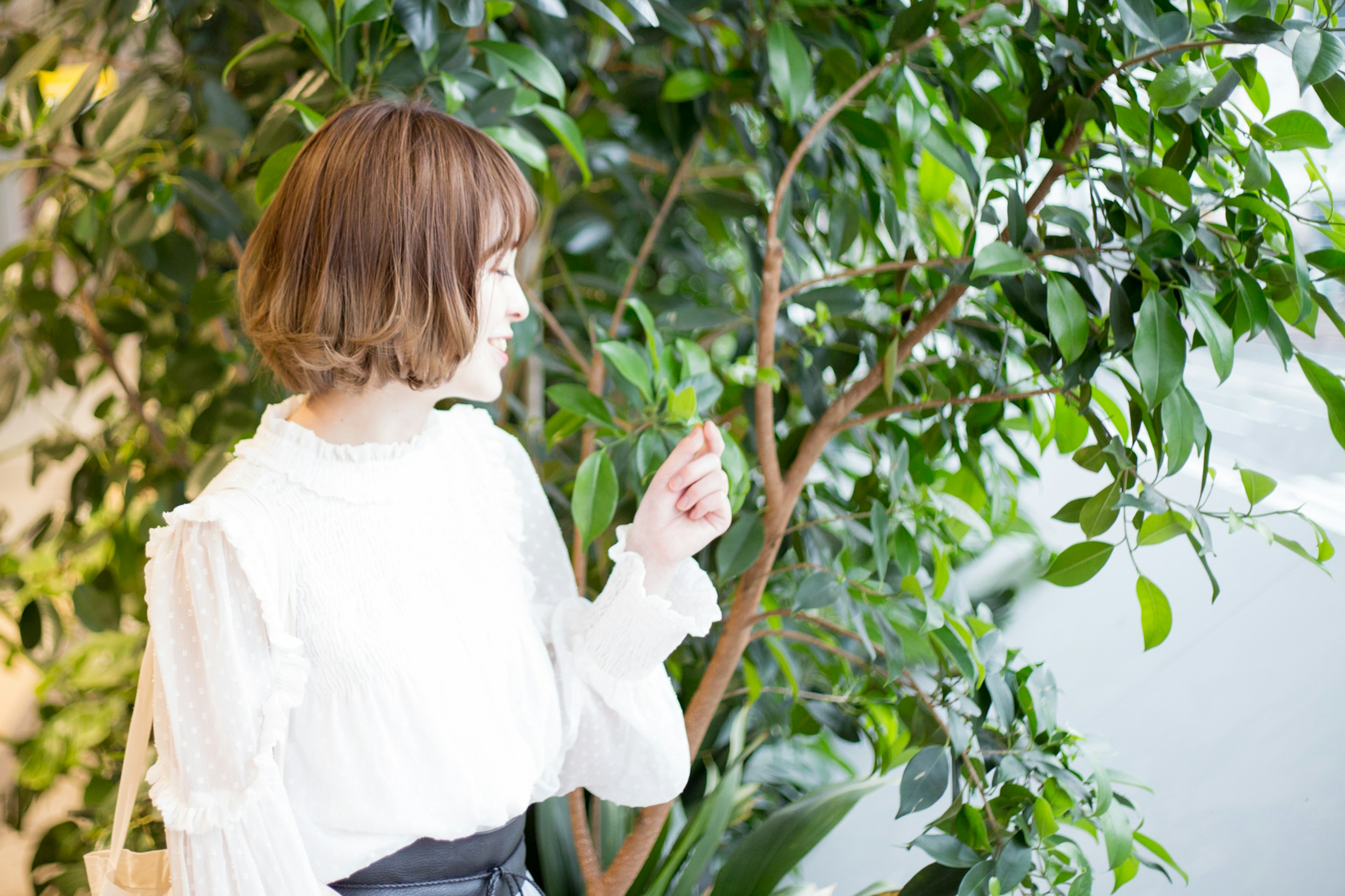 年轻女性在绿色植物附近指着