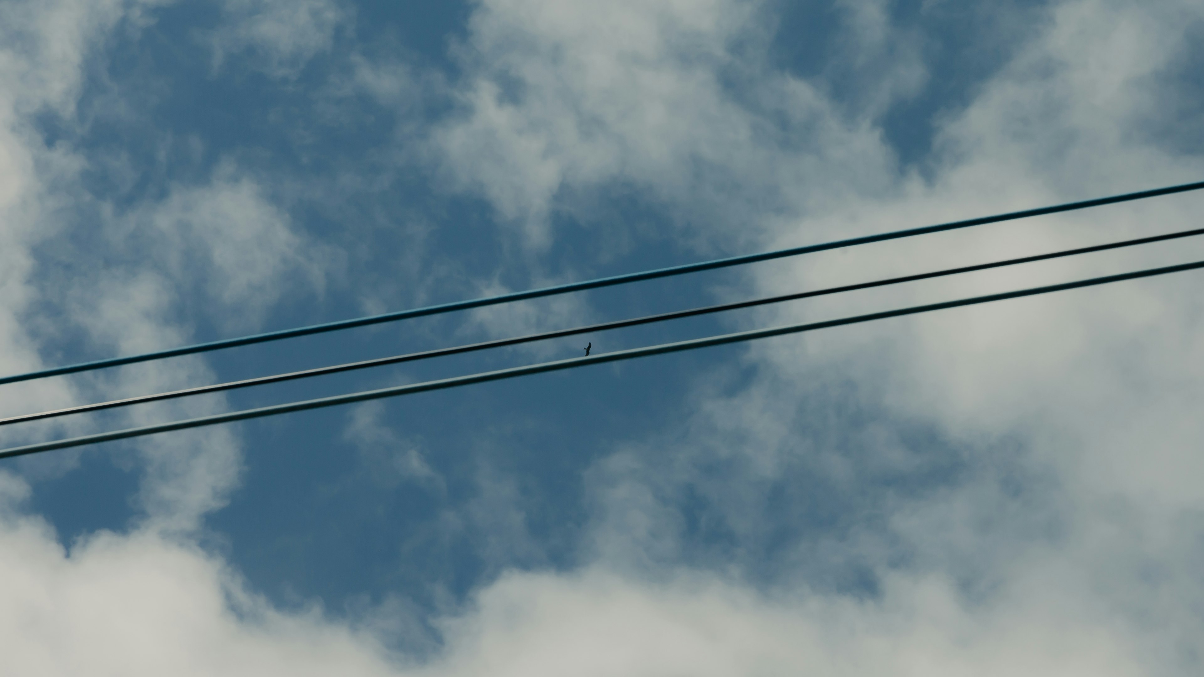 Blauer Himmel mit weißen Wolken und Stromleitungen