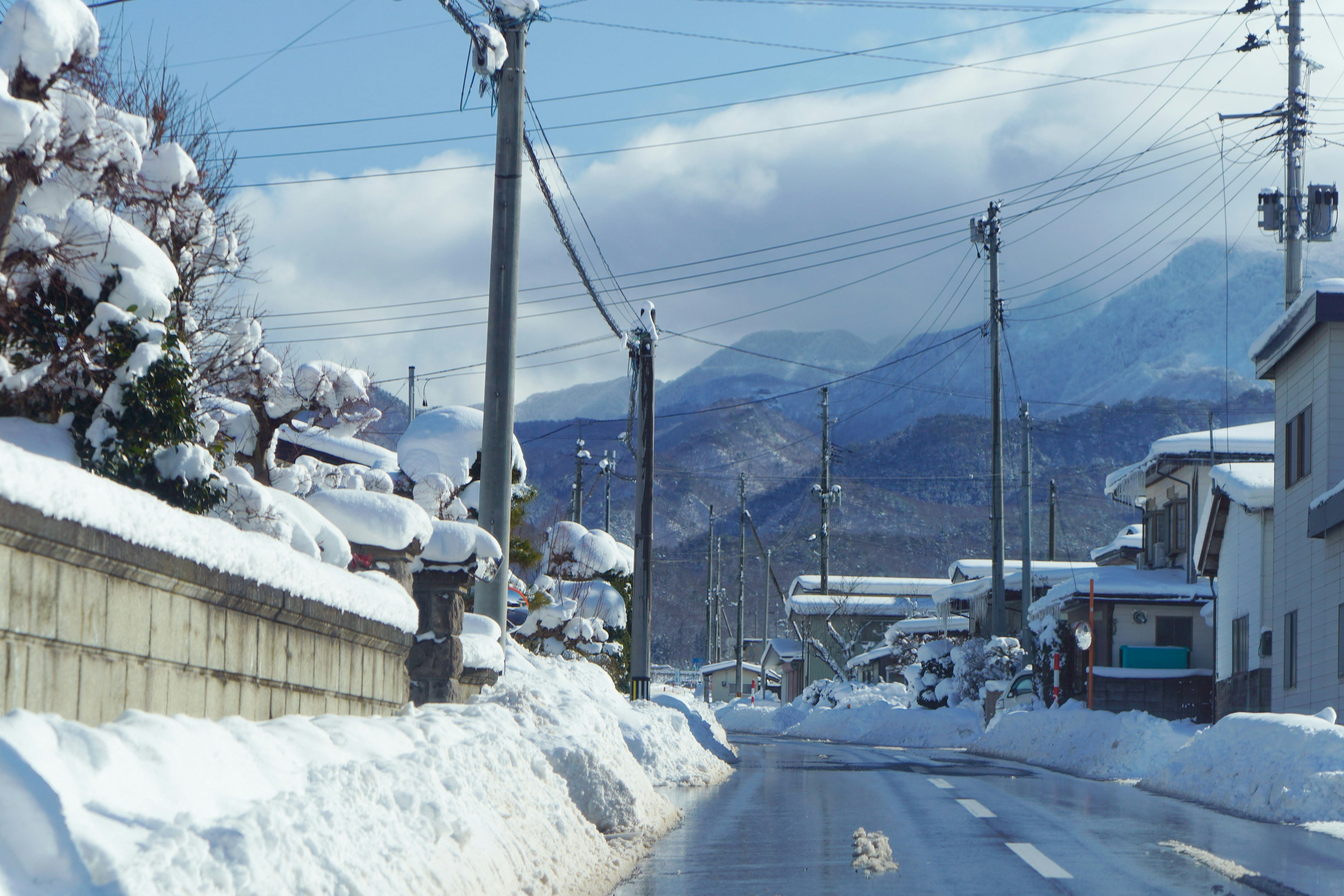 Snow-covered road with mountains in the background