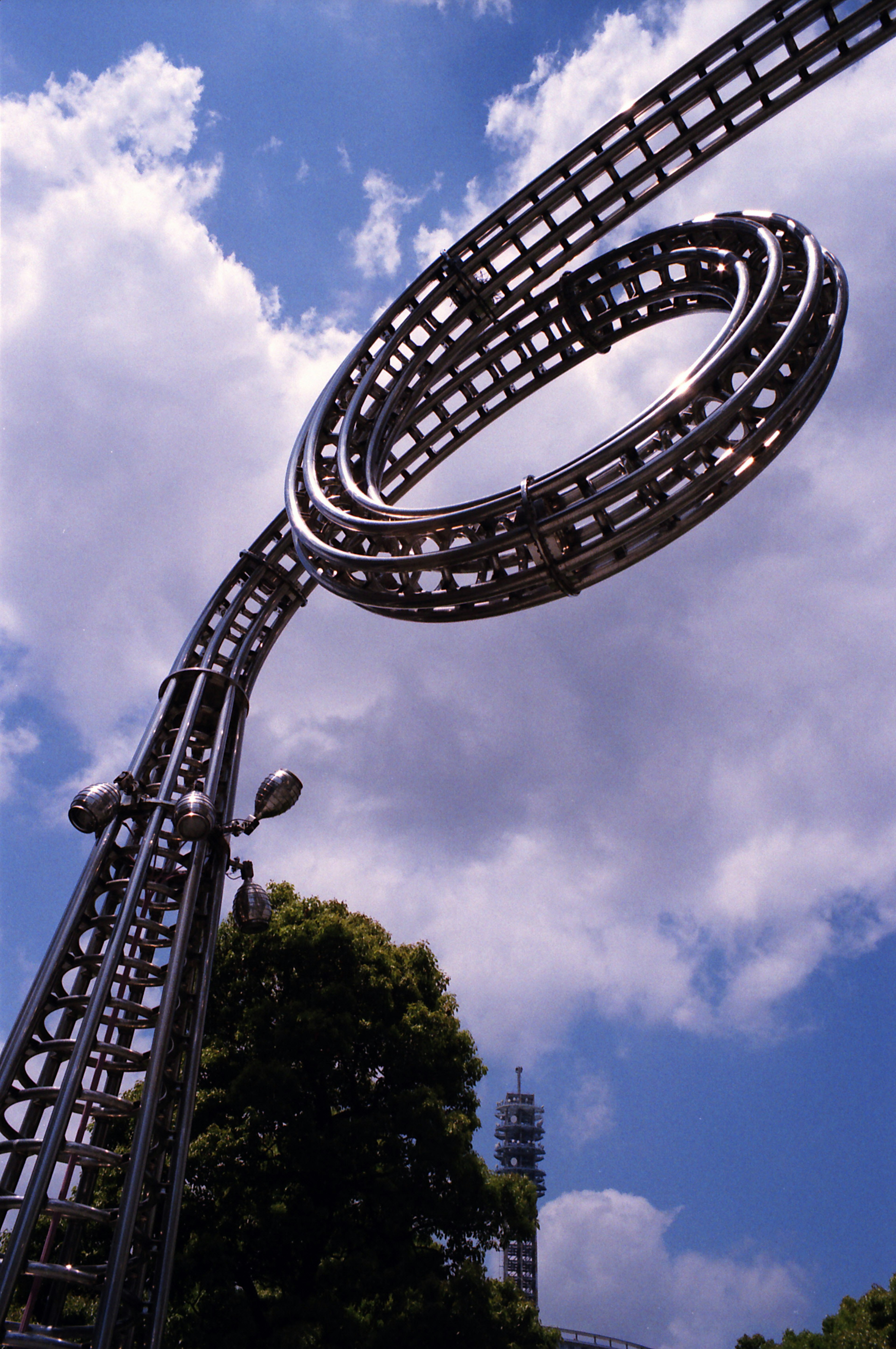 Scultura a forma di anello metallico che si erge sotto un cielo blu