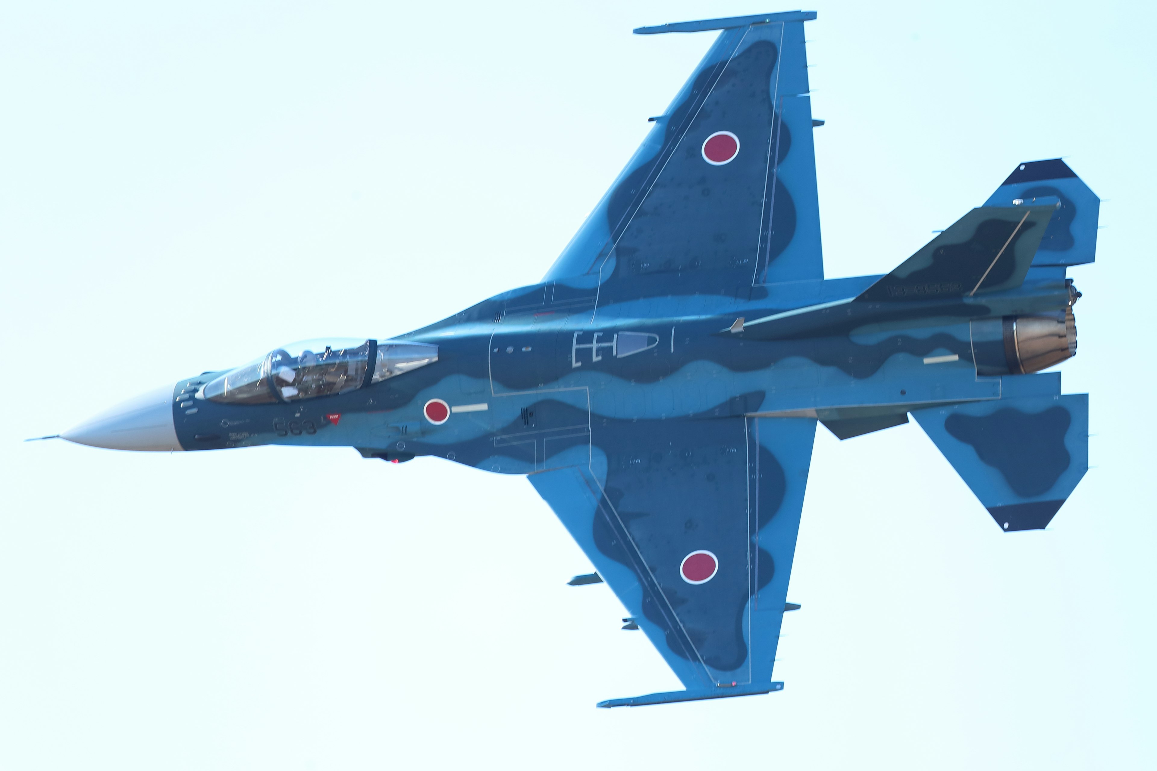 Blue camouflage fighter jet flying in the sky