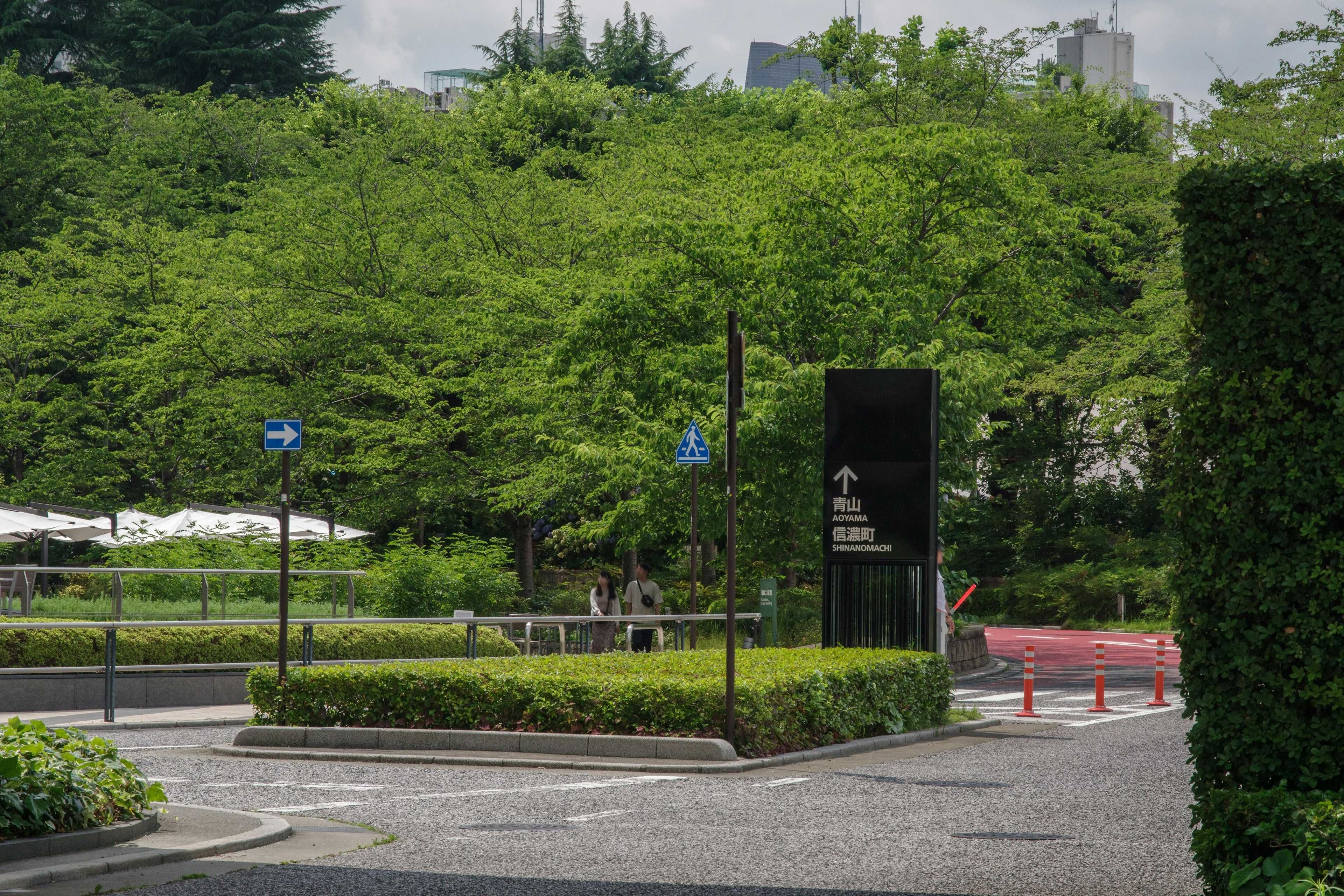 Lush green park scene with a sculpture at the entrance