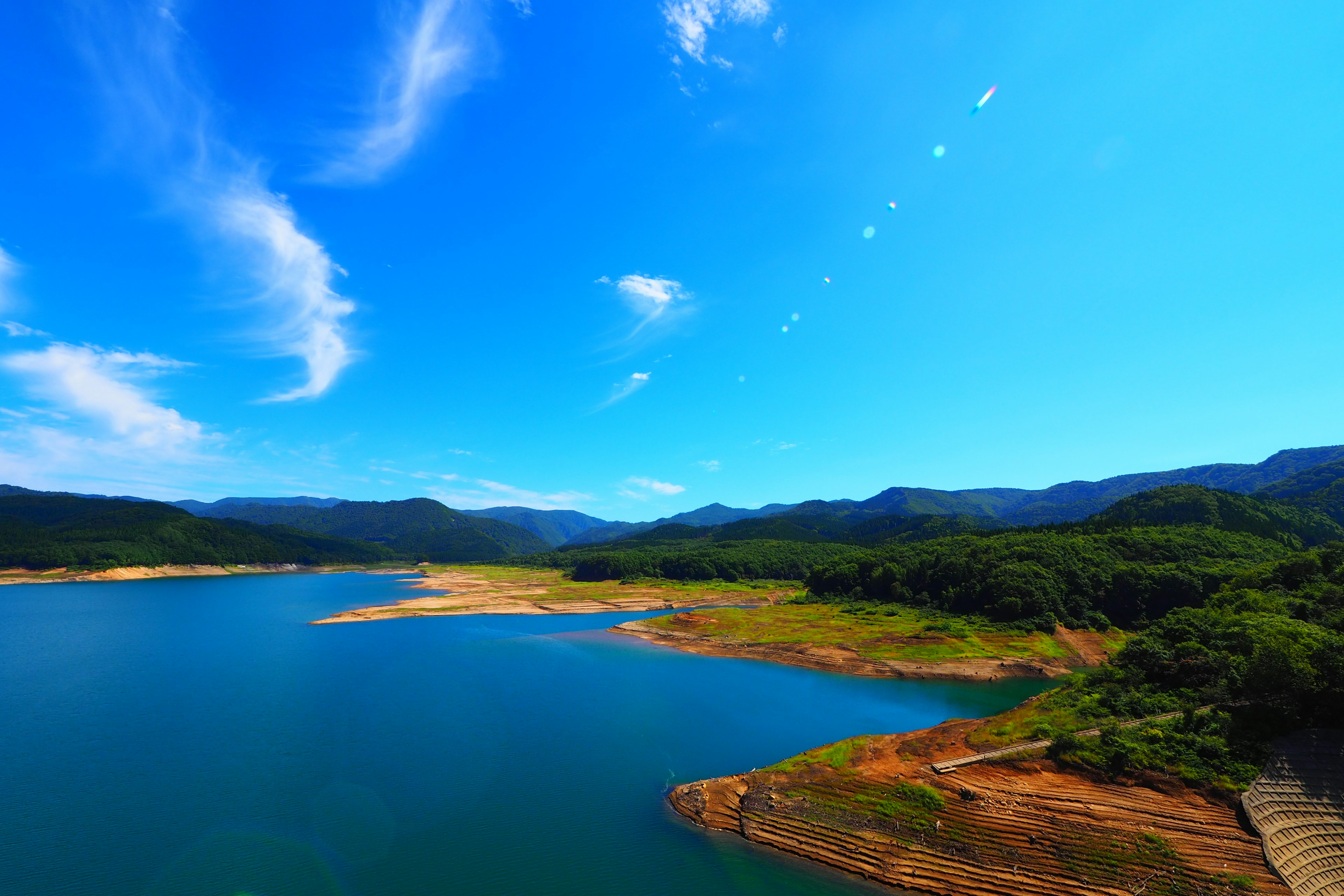 湖泊的风景，四周环绕着绿色的山脉和清澈的蓝天