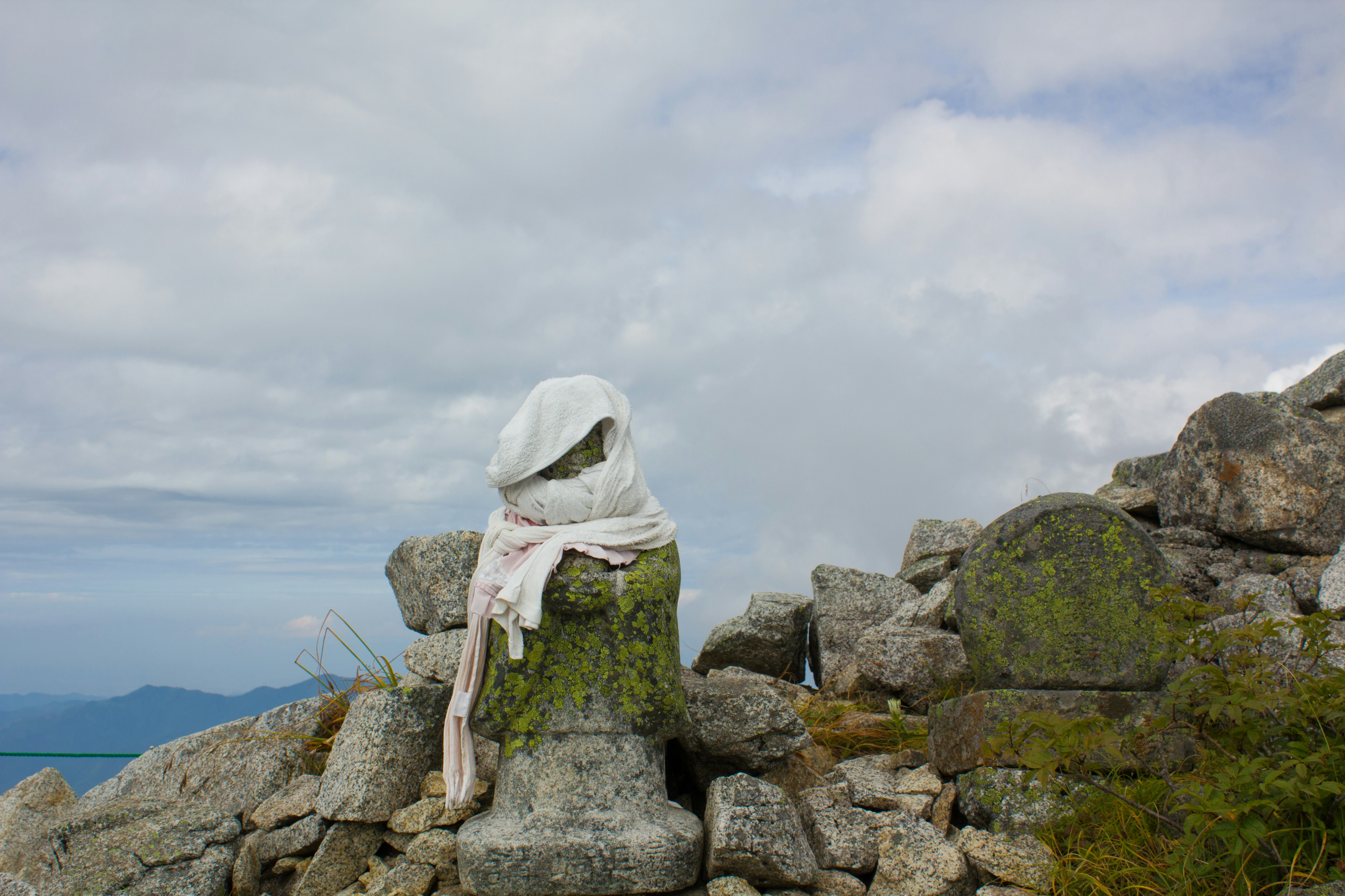 Una estatua de piedra en la cima de la montaña cubierta con una tela blanca