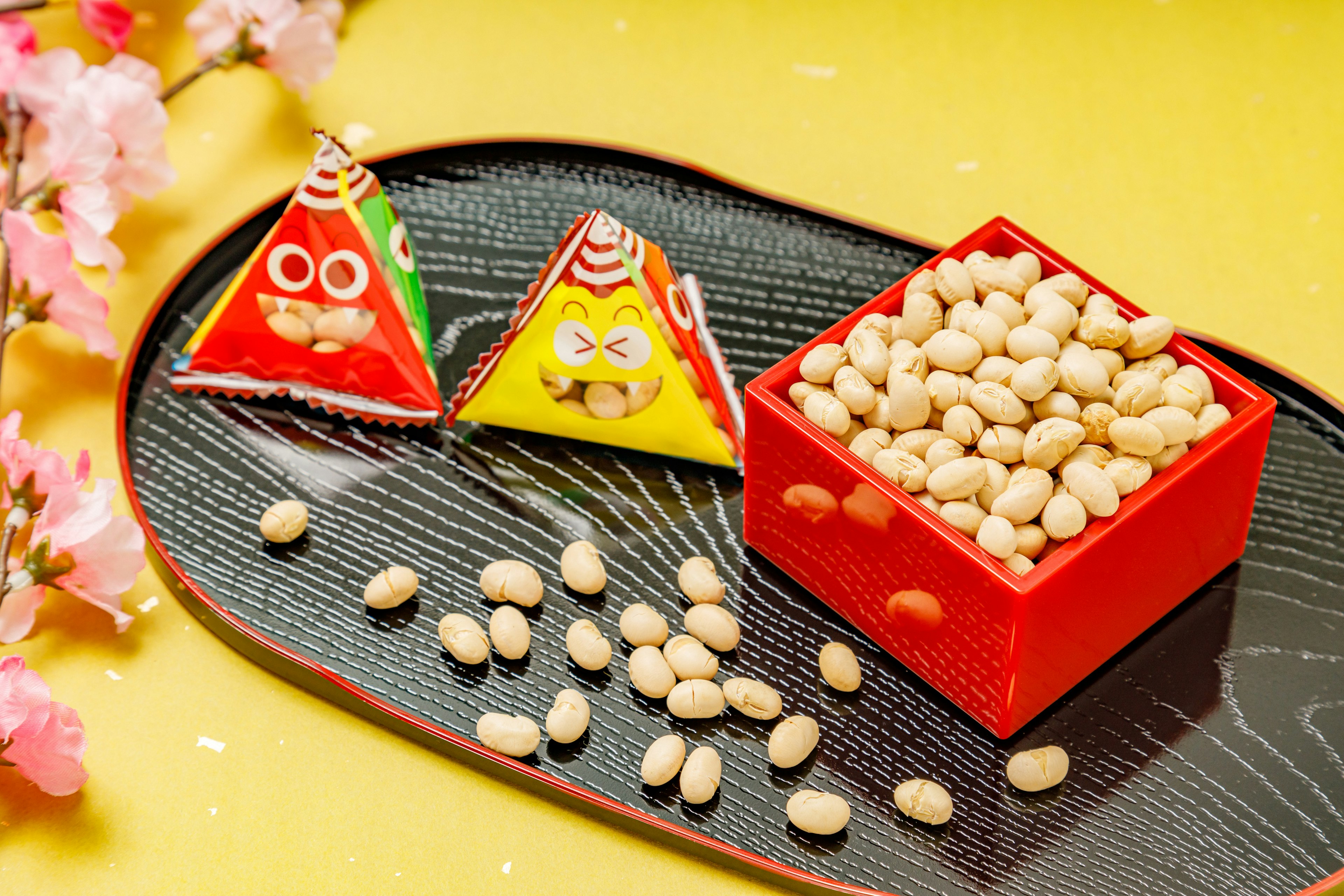 Bonbons triangulaires colorés et une boîte rouge remplie de haricots sur une assiette décorative