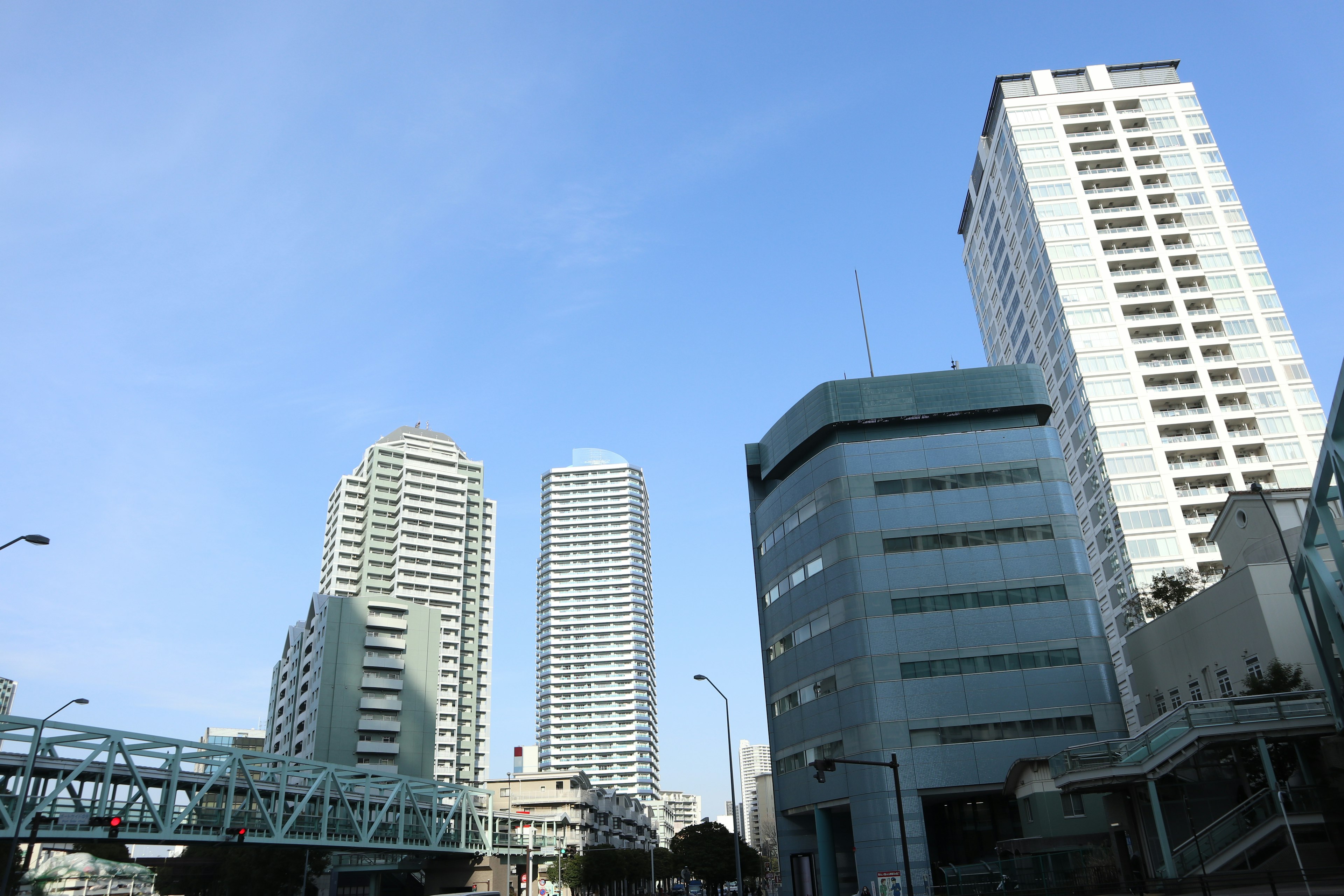 Pemandangan kota dengan gedung pencakar langit dan bangunan di bawah langit biru yang cerah