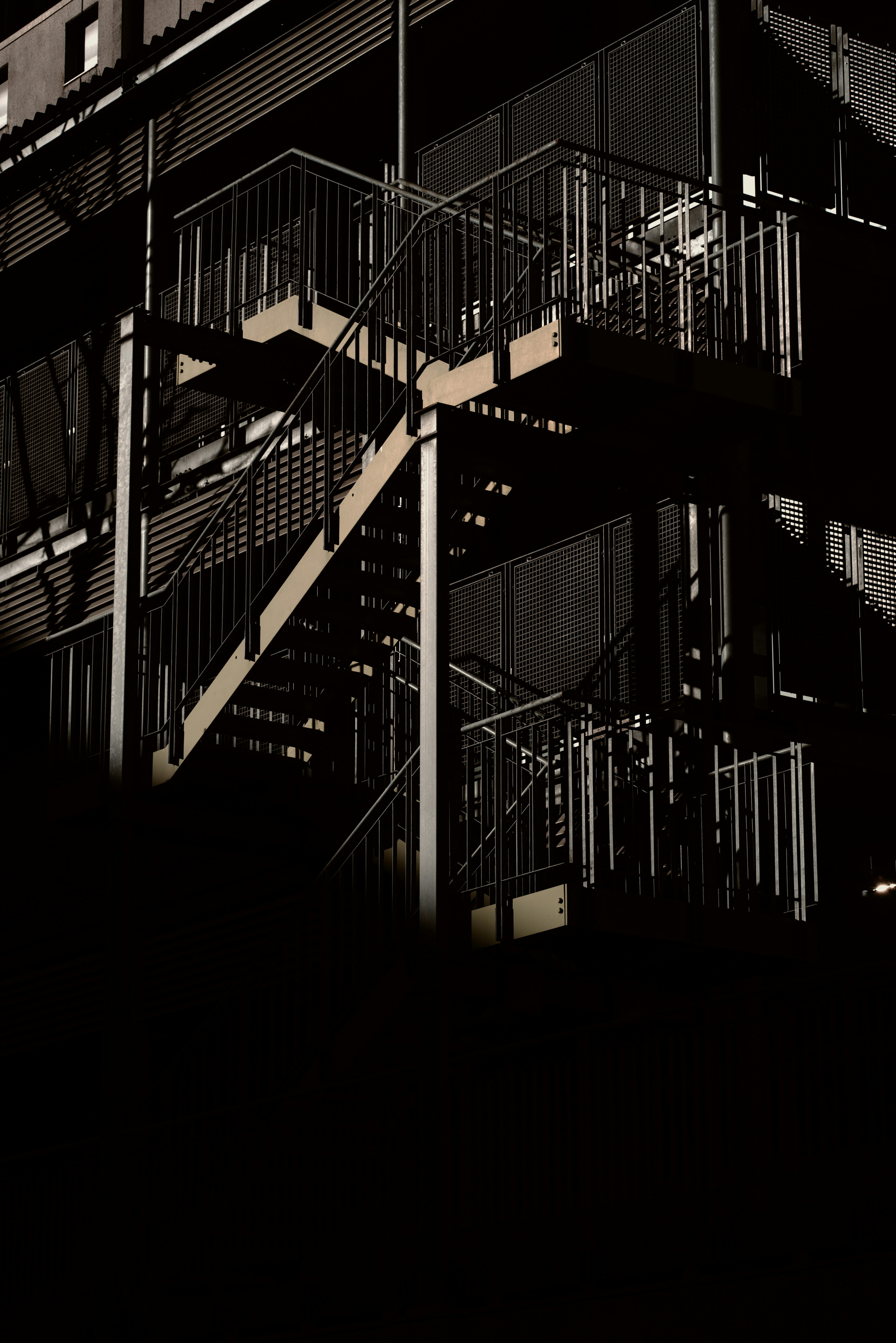 Metal staircase structure illuminated against a dark background