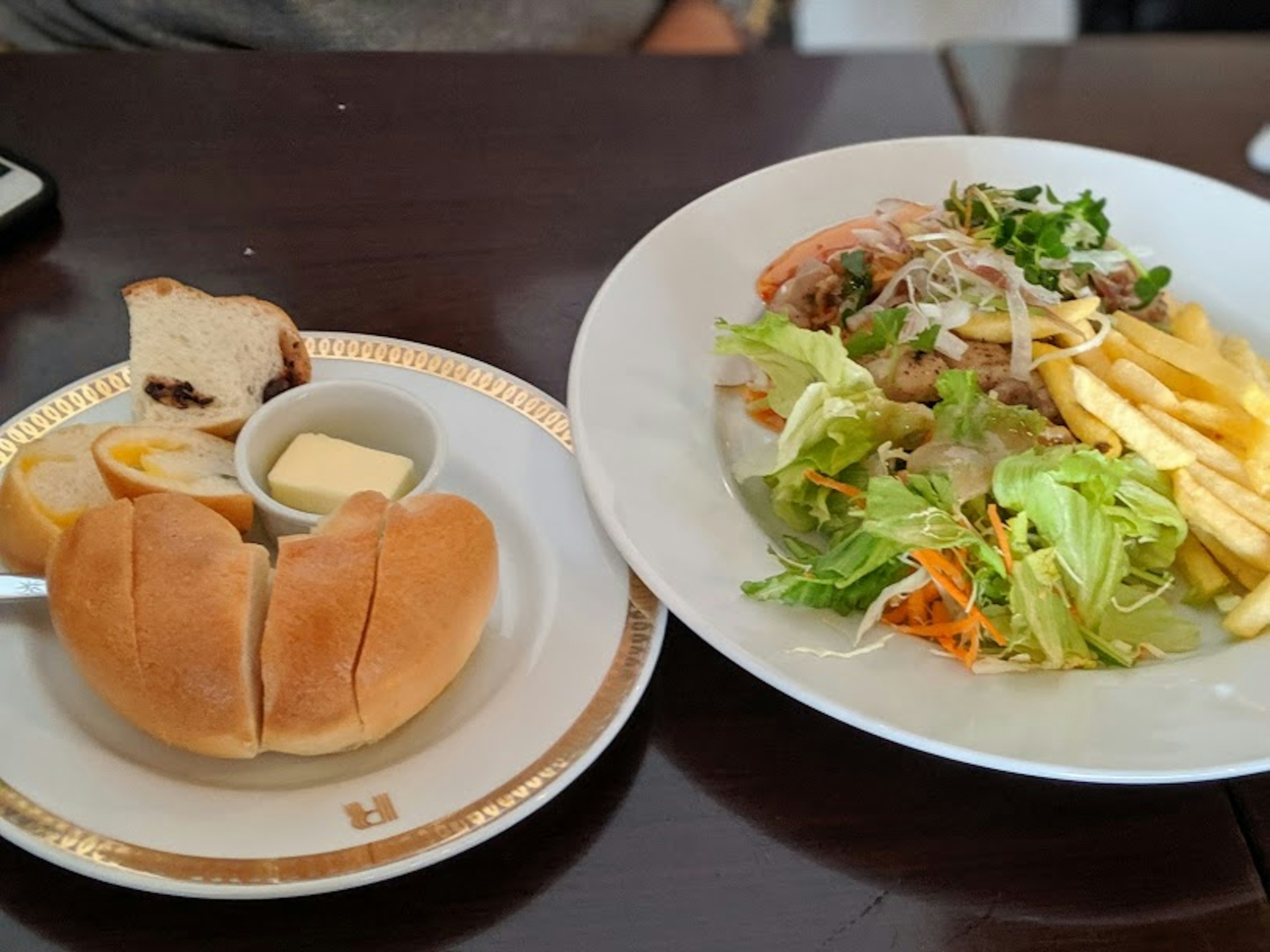 サラダとフライドポテトを添えた料理とバターが乗ったパン