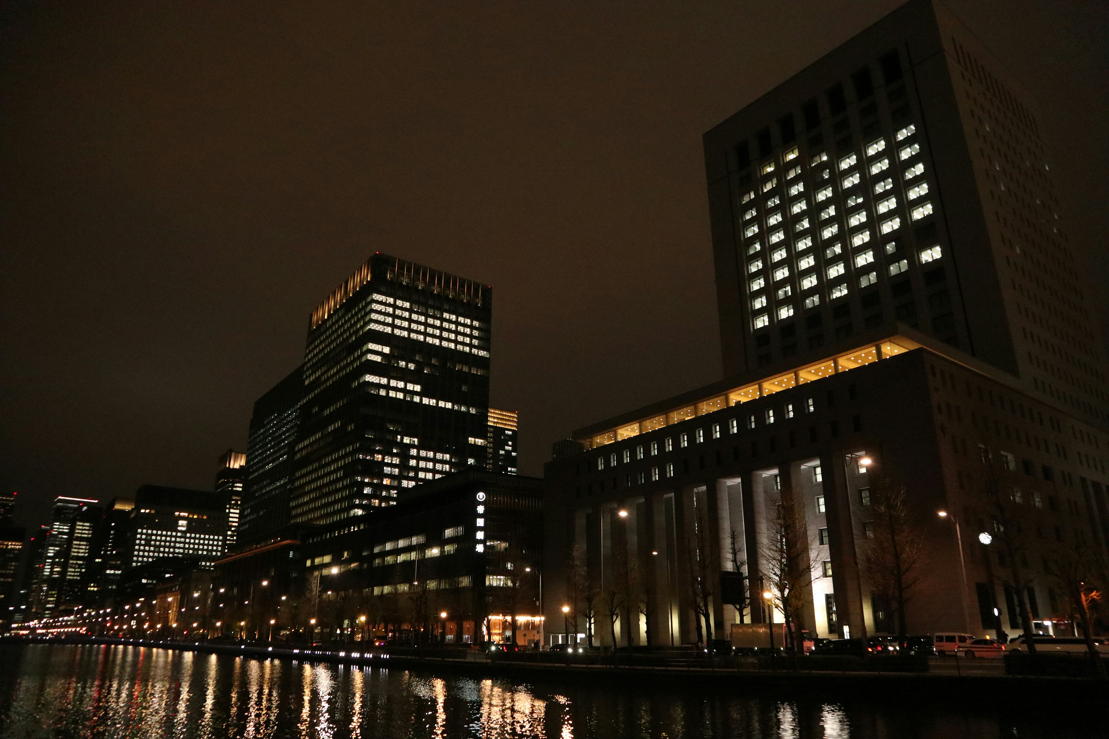 Paesaggio urbano notturno con grattacieli e riflessi nel fiume