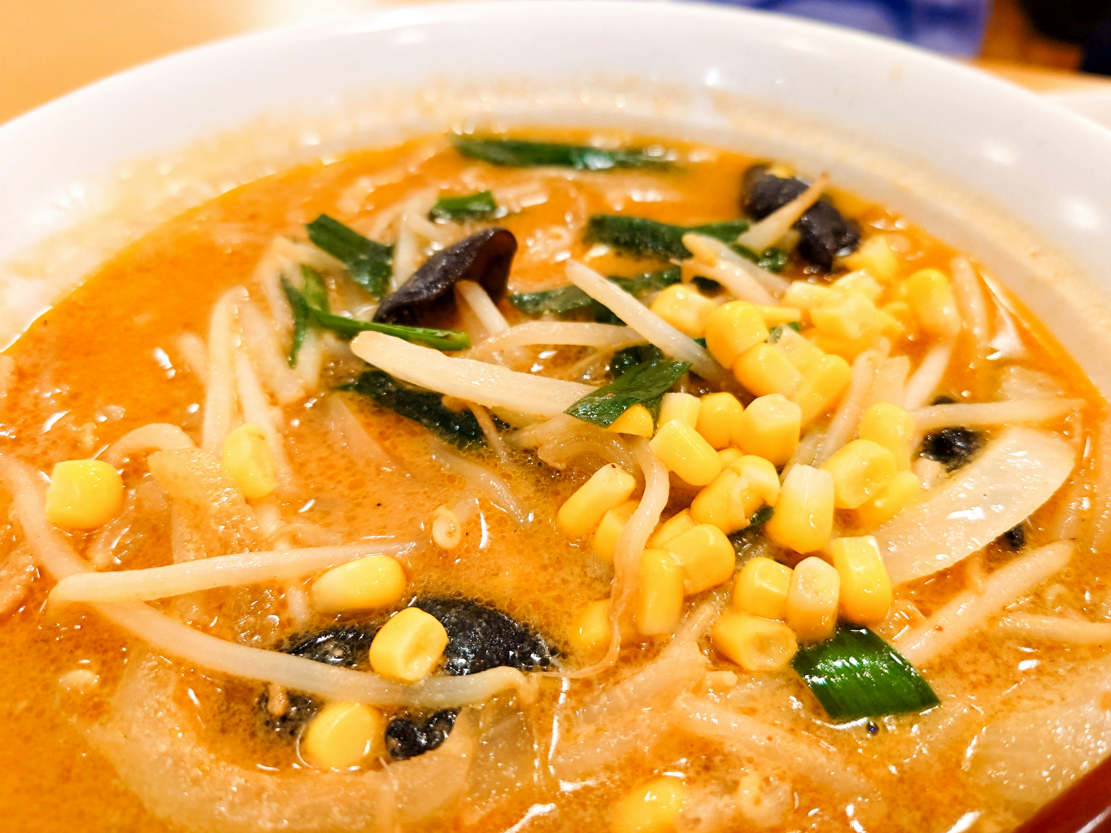 Ramen lezat dengan jagung, kecambah, dan jamur hitam dalam kaldu