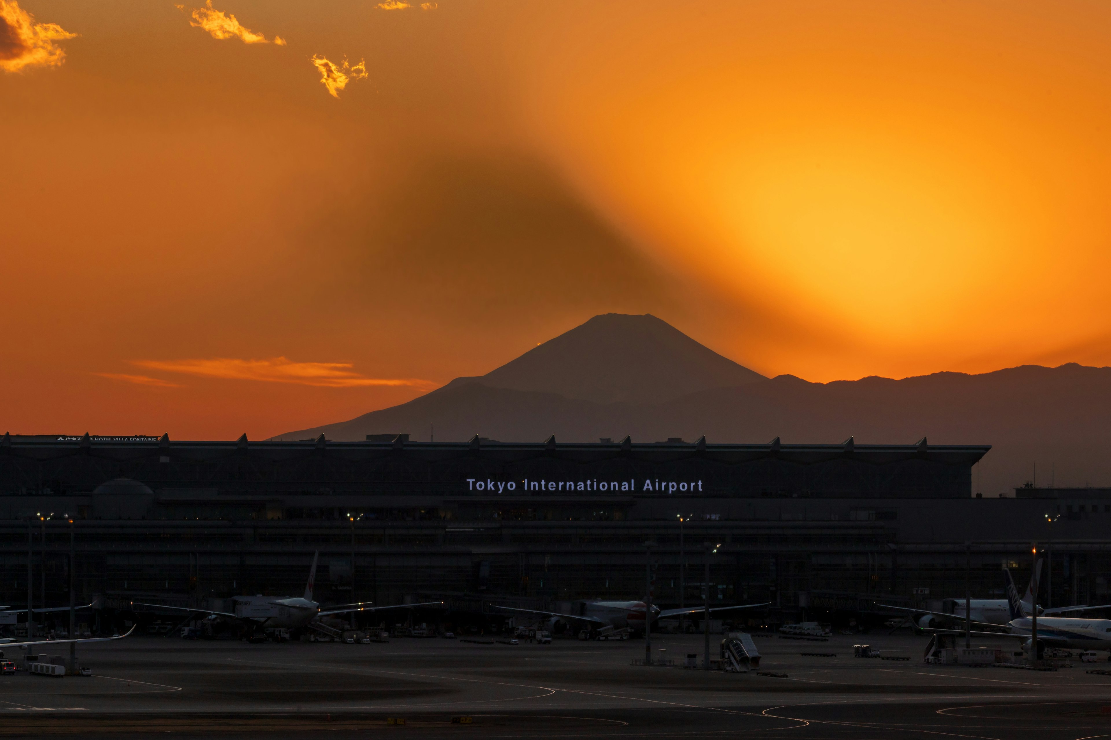 Vista del tramonto sull'aeroporto internazionale di Tokyo con il monte Fuji sullo sfondo