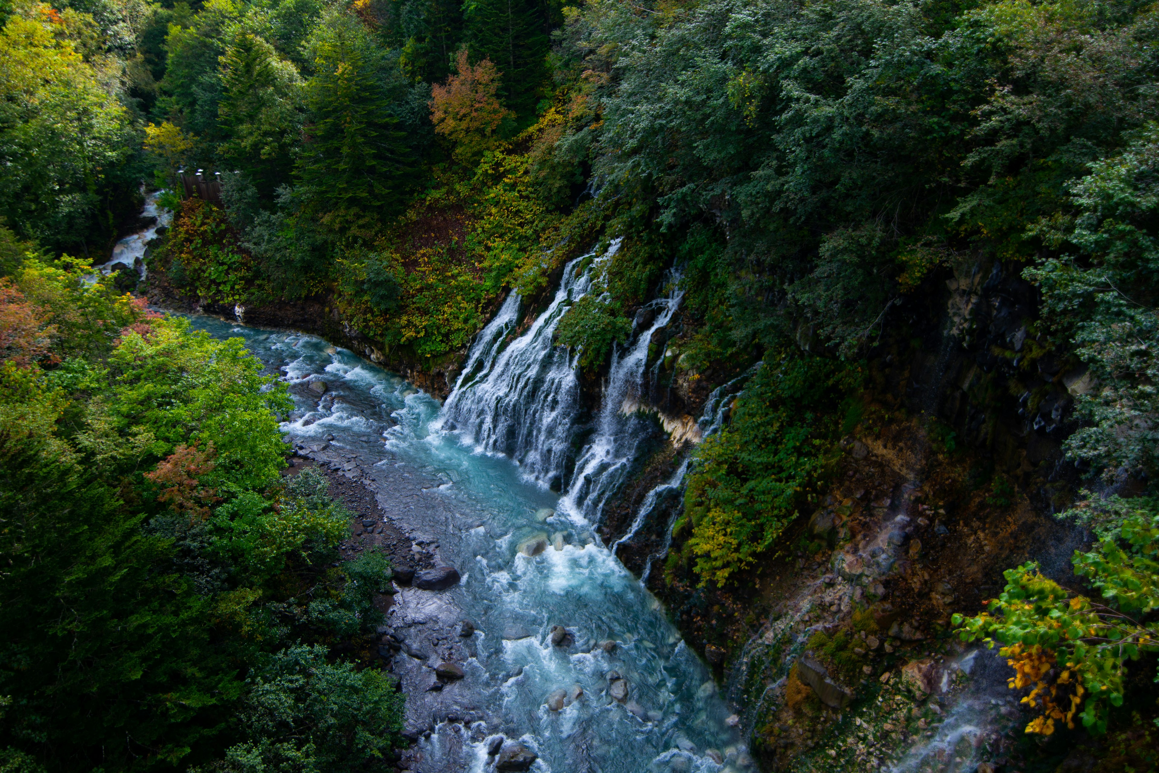 Lanskap subur dengan sungai biru dan air terjun