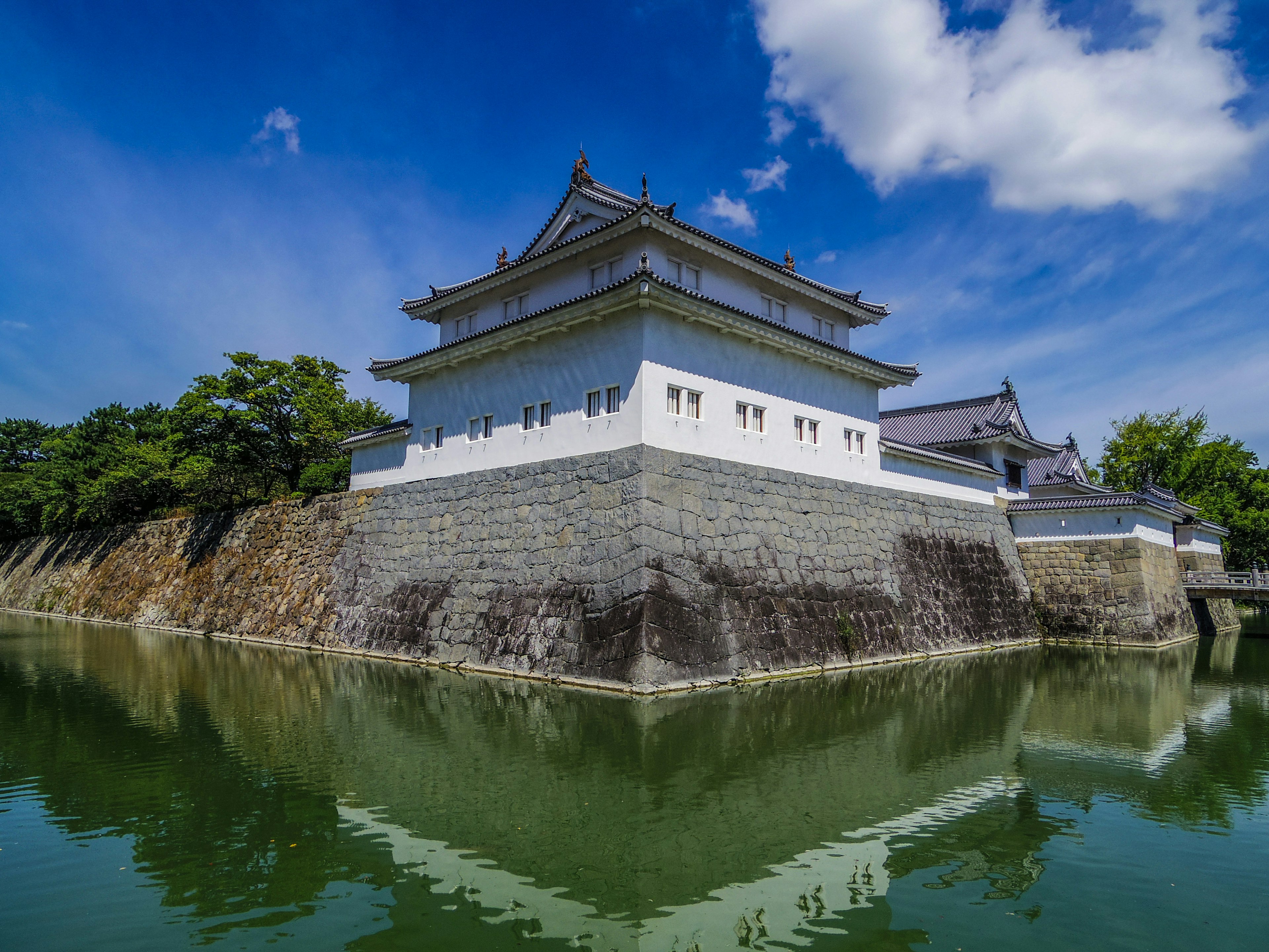 Castle exterior with reflection in water under a clear blue sky