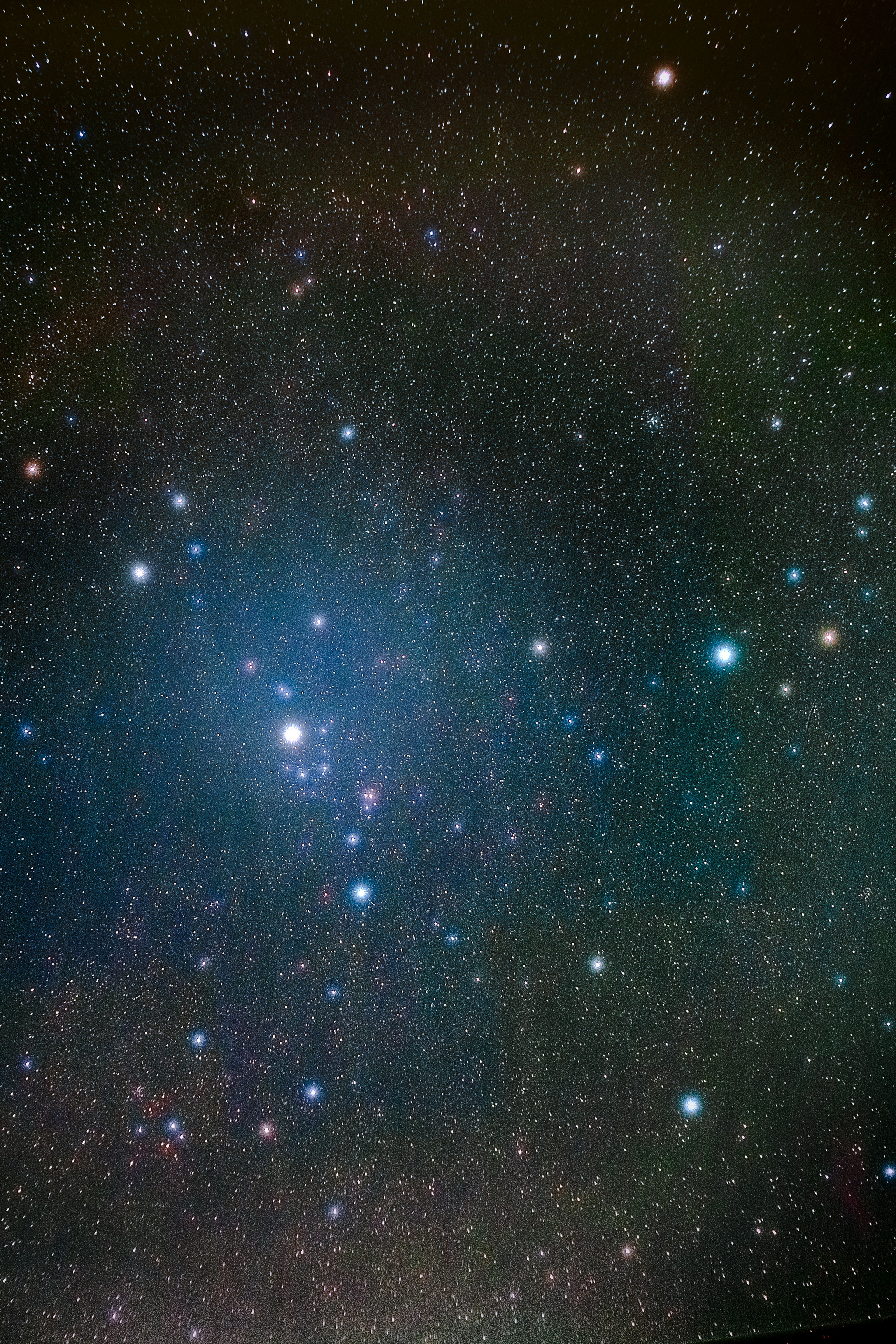 Immagine di un cielo stellato con stelle luminose e una nebulosa blu