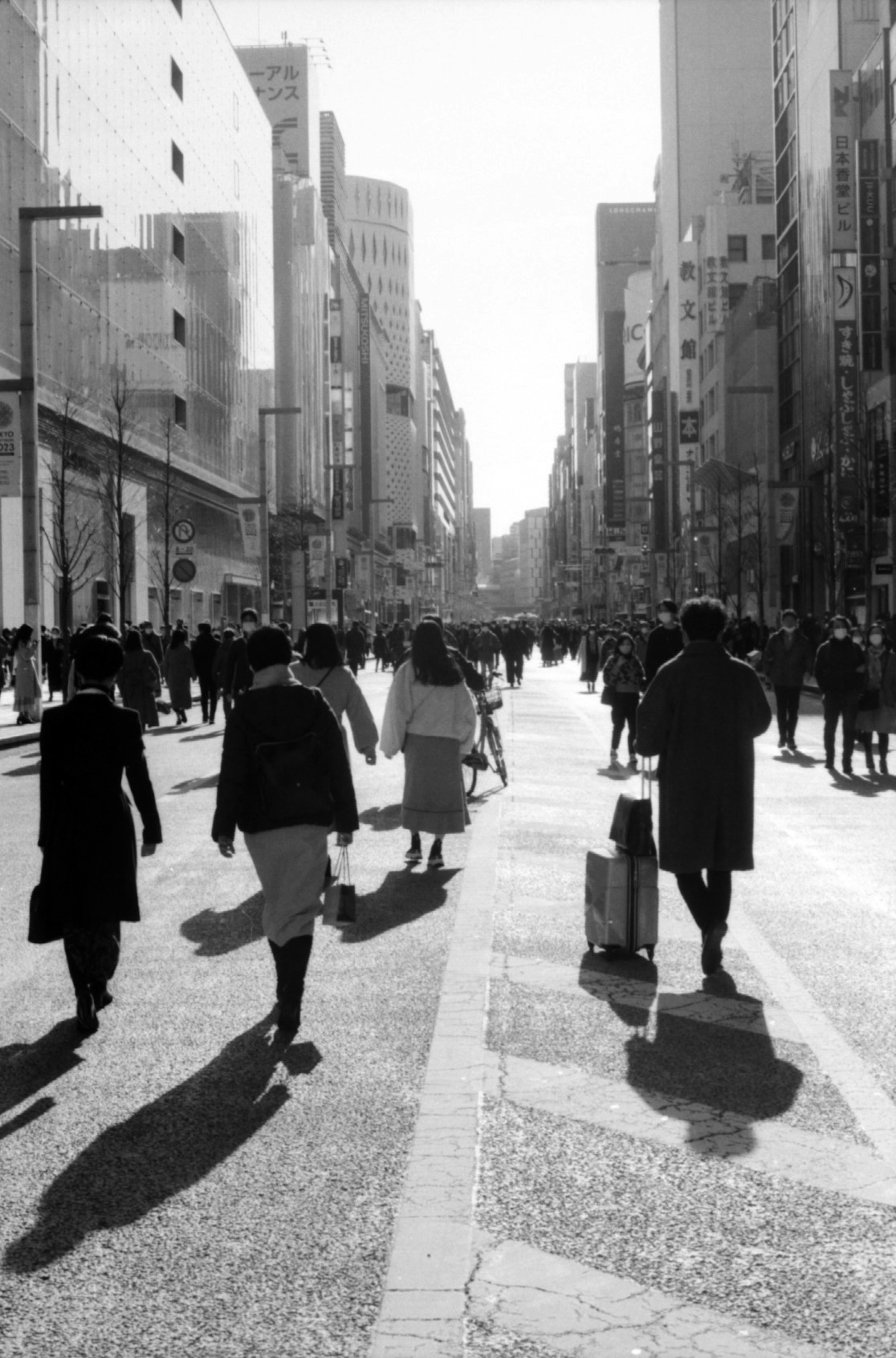 Black and white city scene with people walking on the street