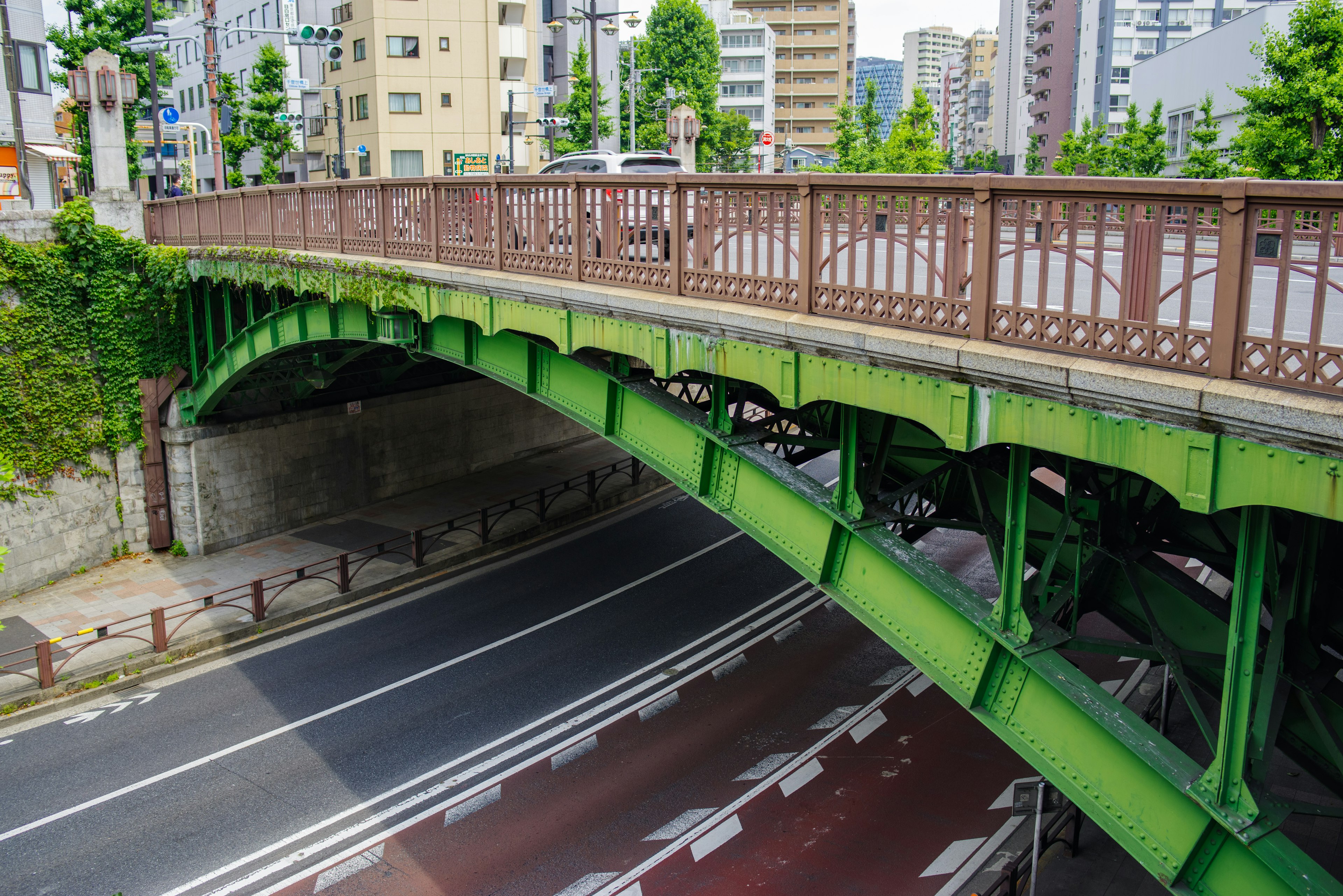 Green arch bridge overlooking a city street