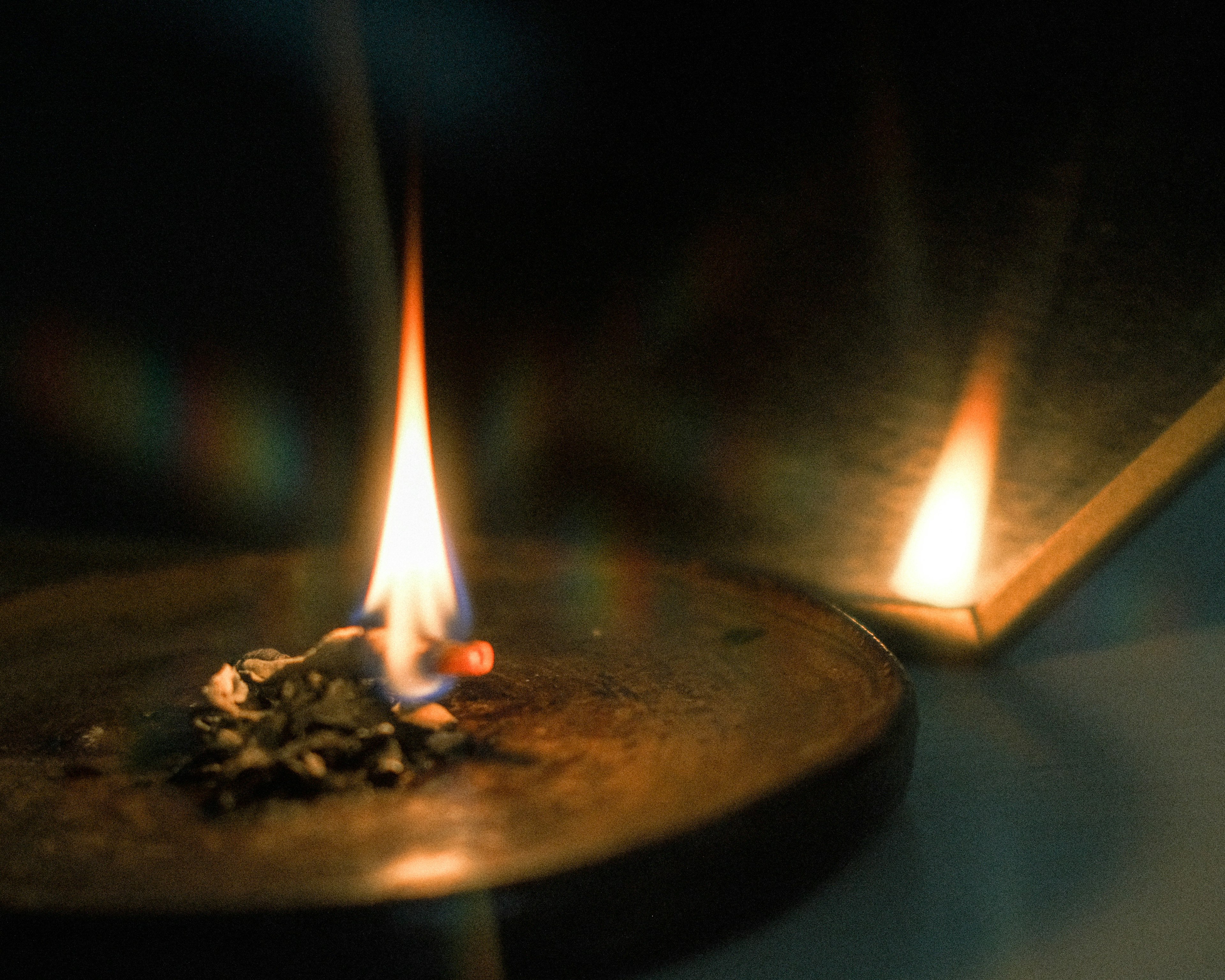 Flames burning on a dish with reflected light in the background