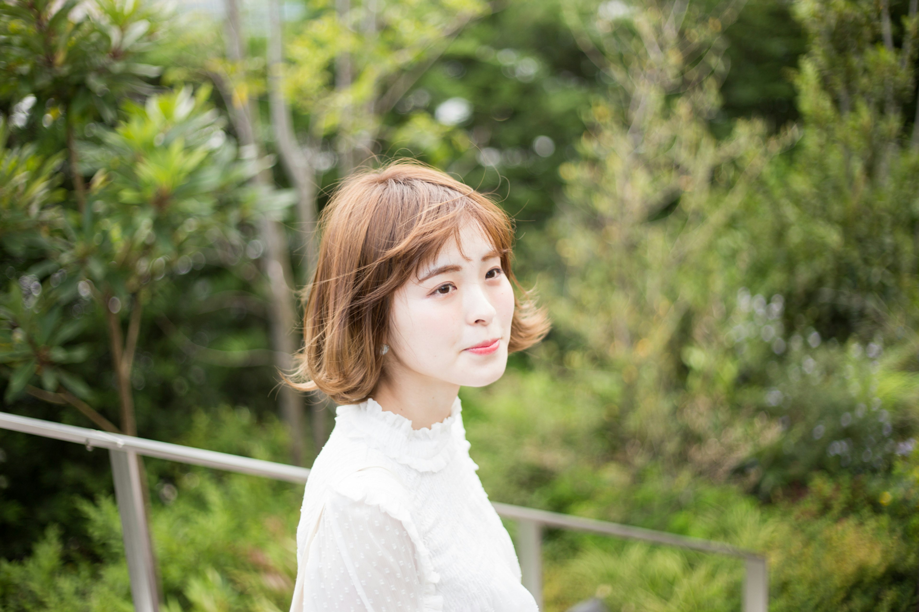 Woman smiling in profile against a green background