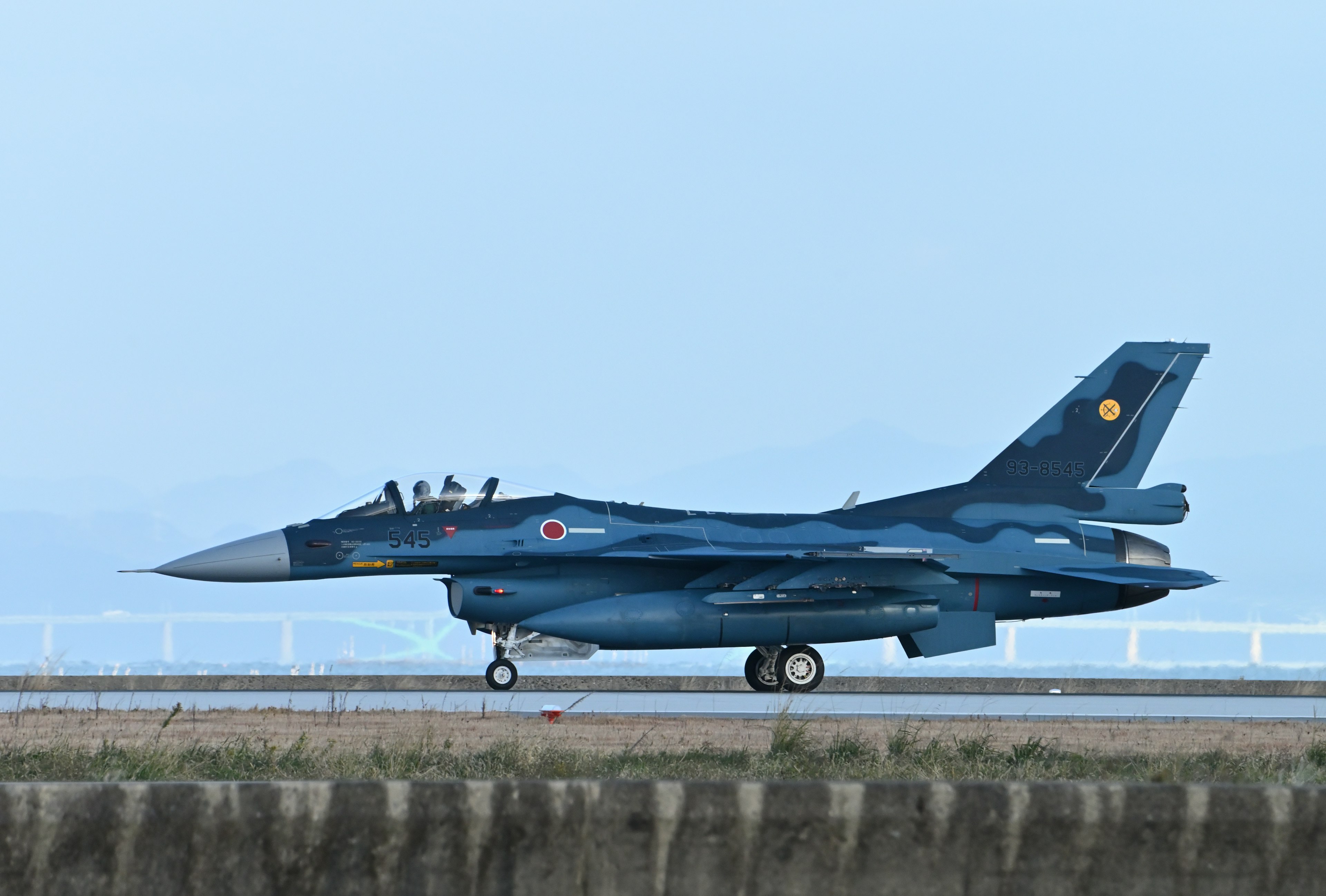 Blue F-2 fighter jet taxiing on the runway