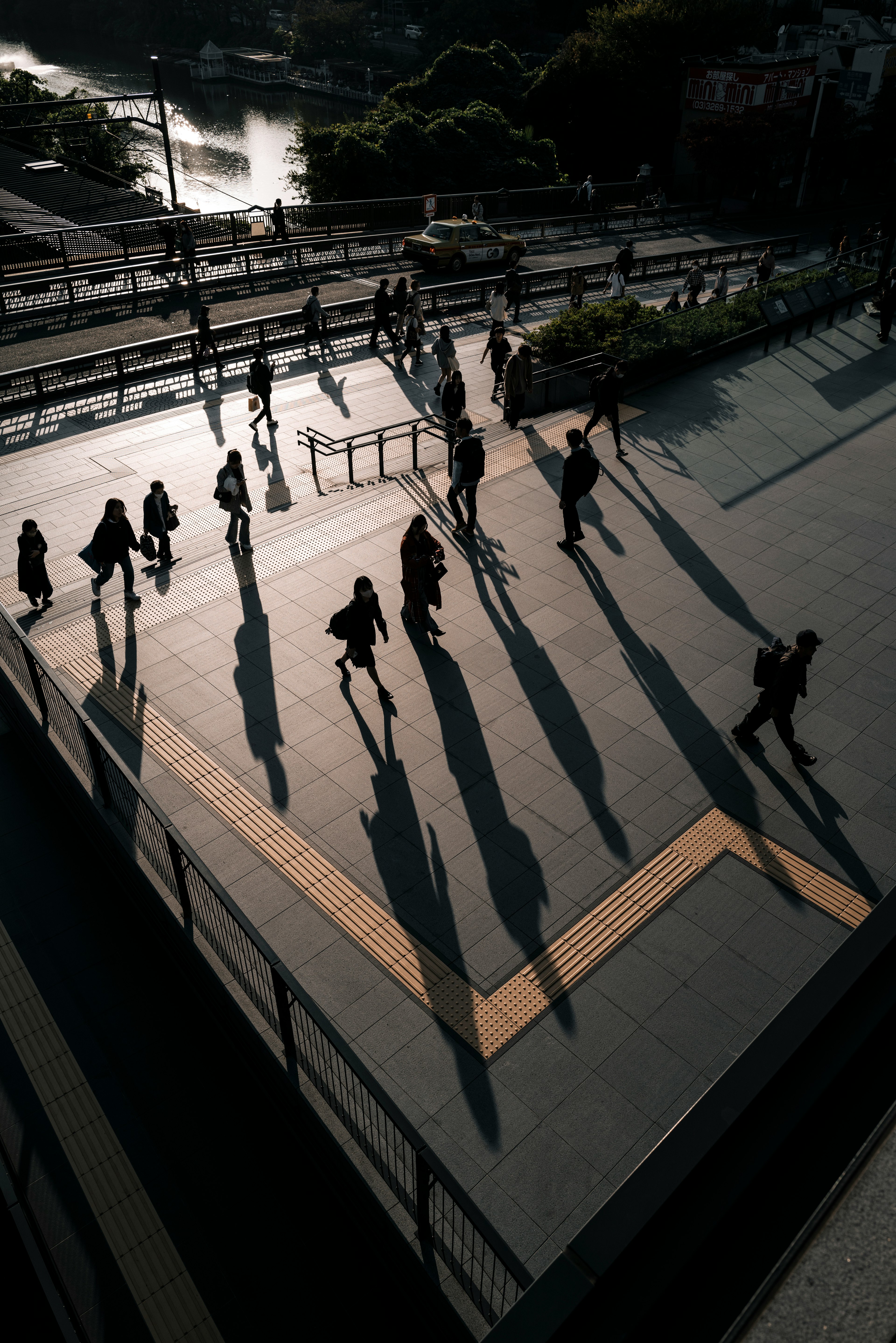 Fußgänger bewegen sich in einer städtischen Umgebung mit sichtbaren Schatten