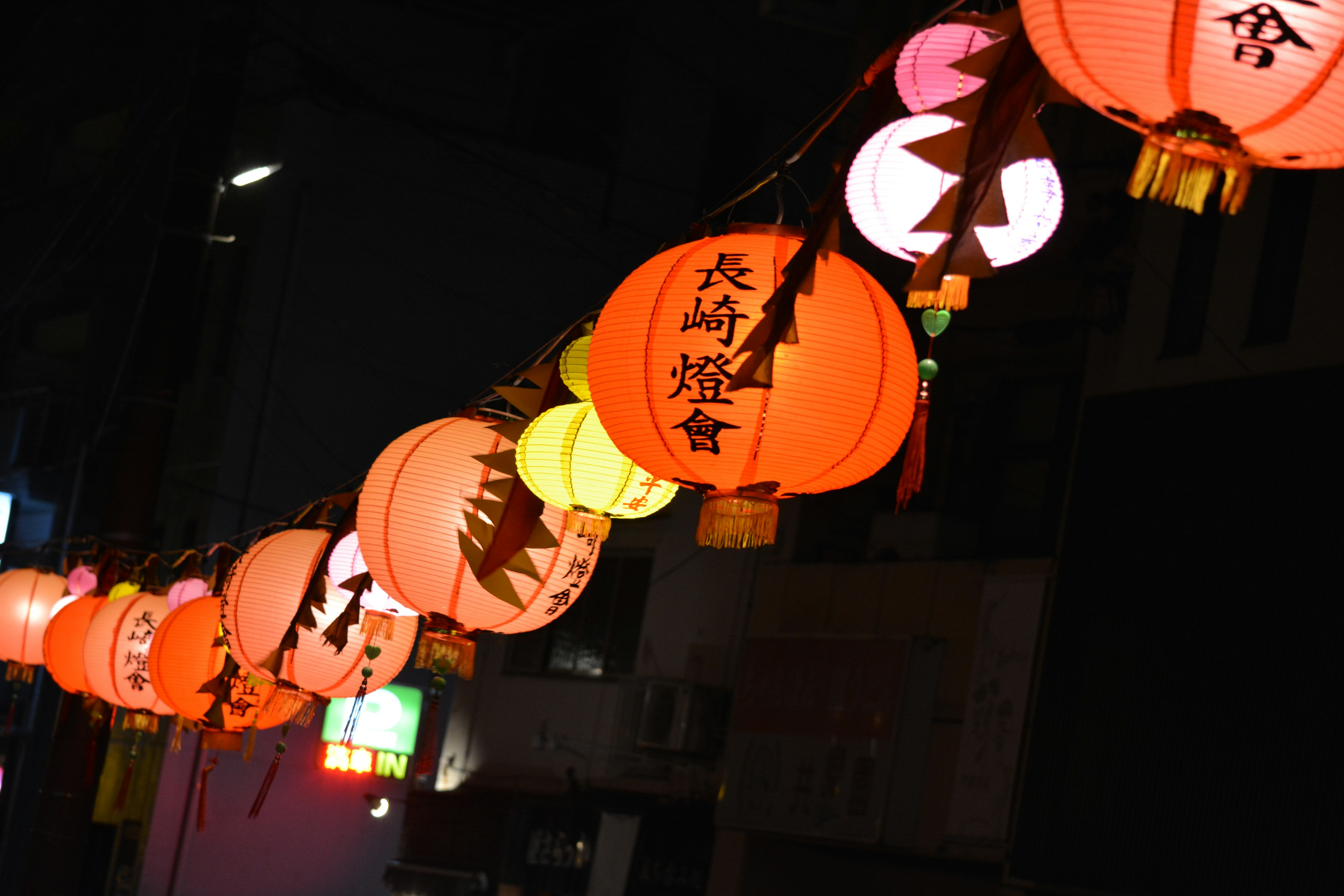 Colorful lanterns hanging in a night street with glowing lights