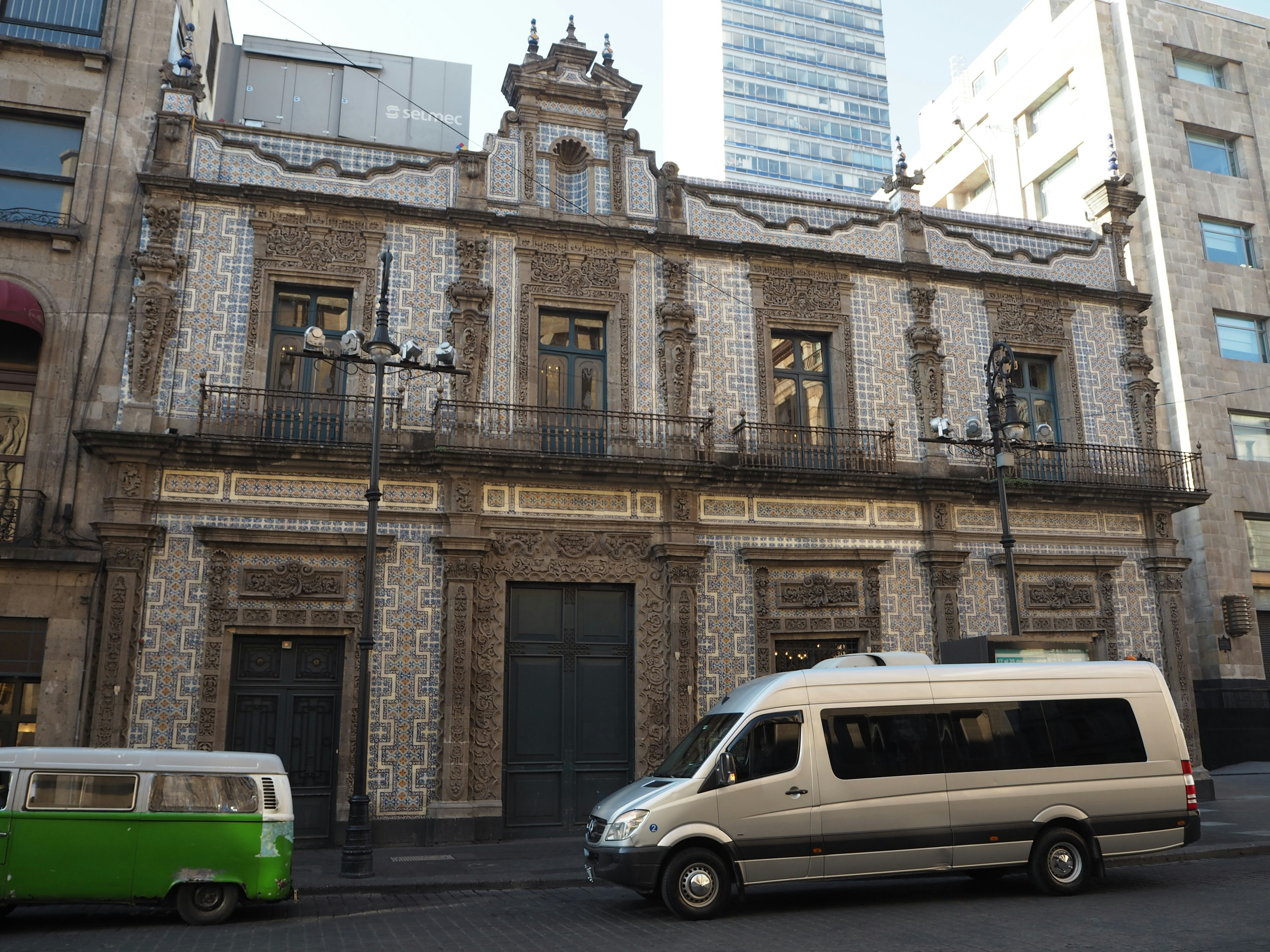 Historic building in Mexico City with modern vehicles parked in front