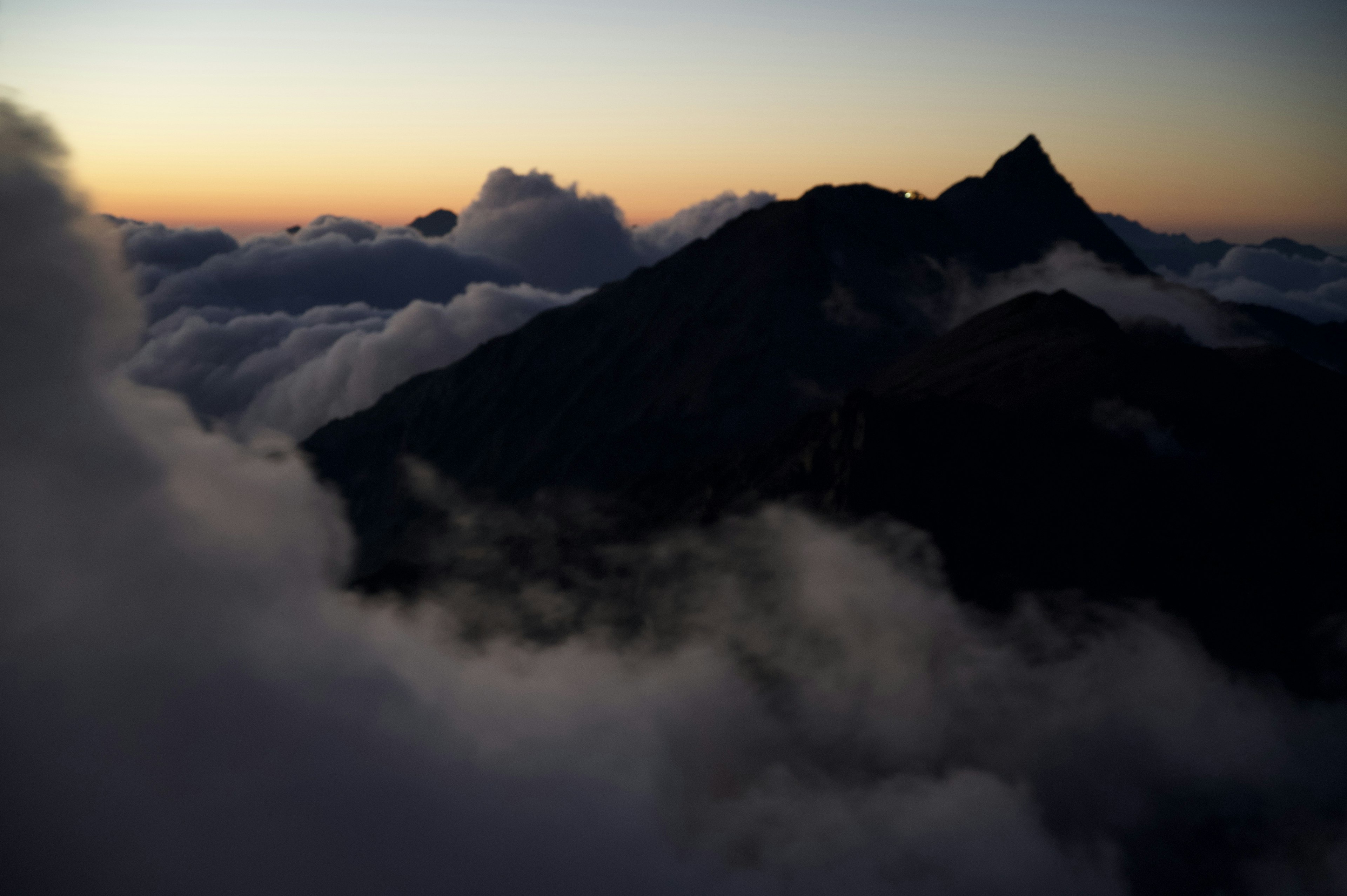 Silhouette eines Berges umgeben von Wolken in der Dämmerung