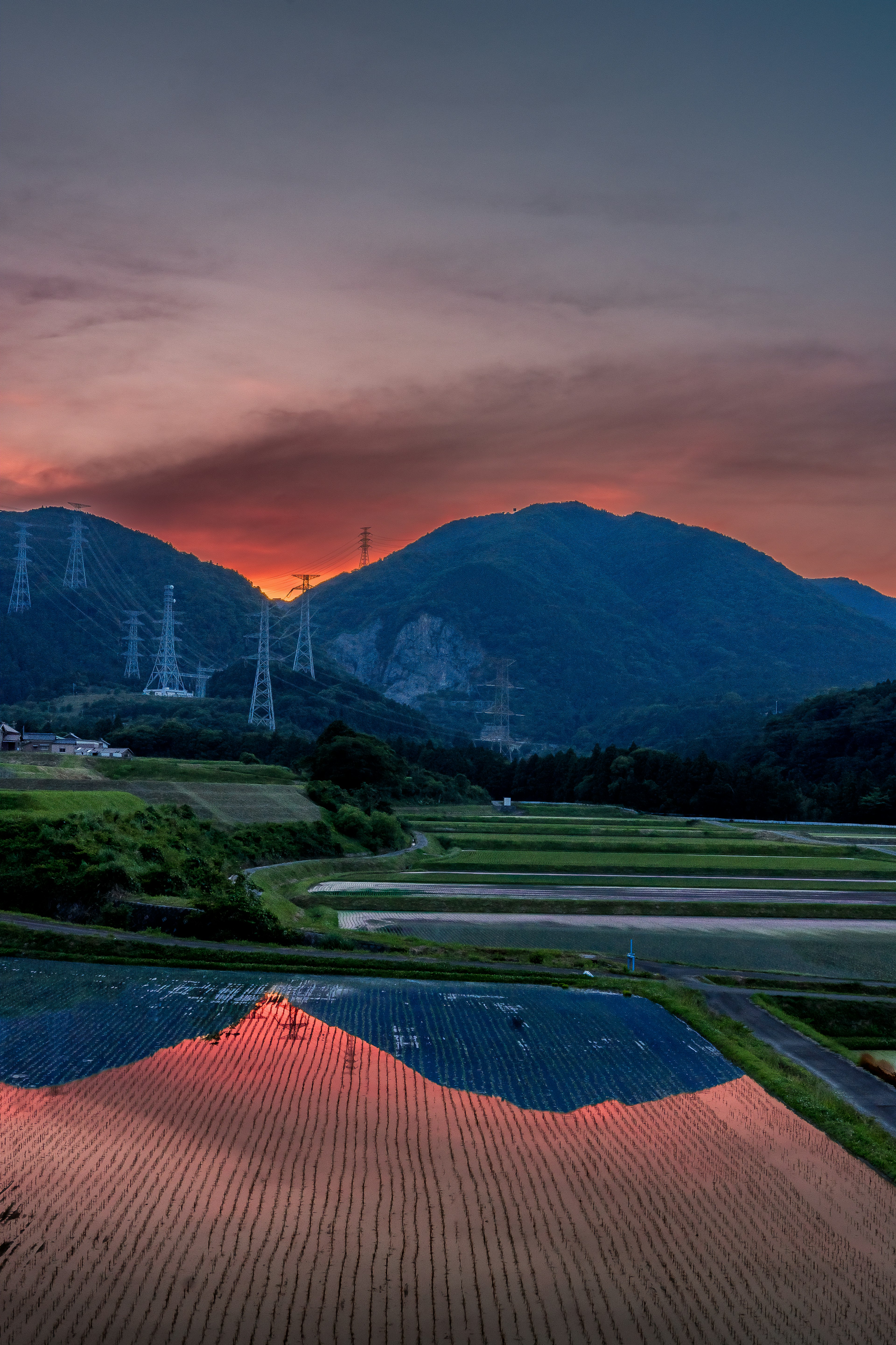 Vue pittoresque des montagnes et des rizières reflétant un beau coucher de soleil