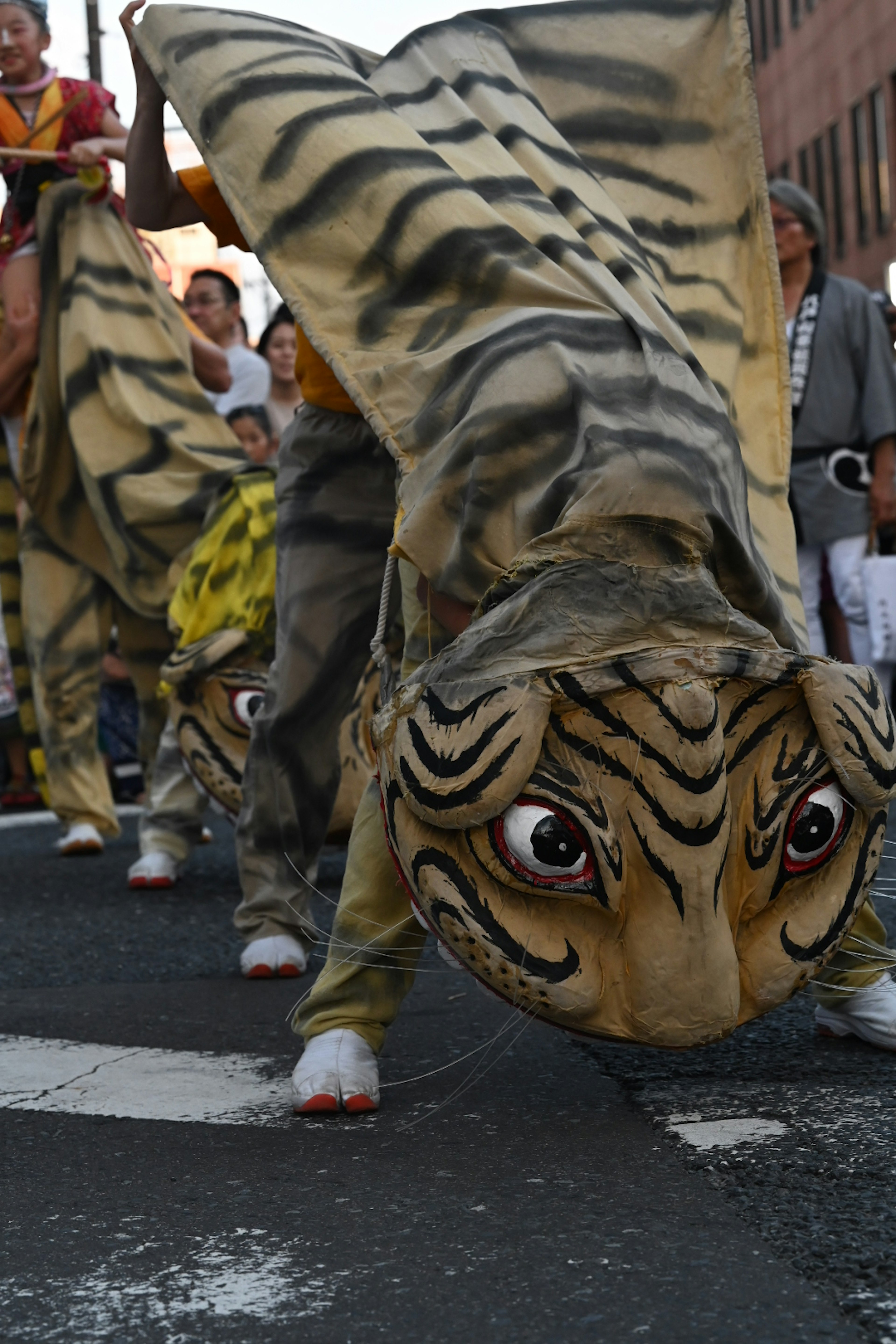 Penampil dalam kostum harimau berjalan di jalan