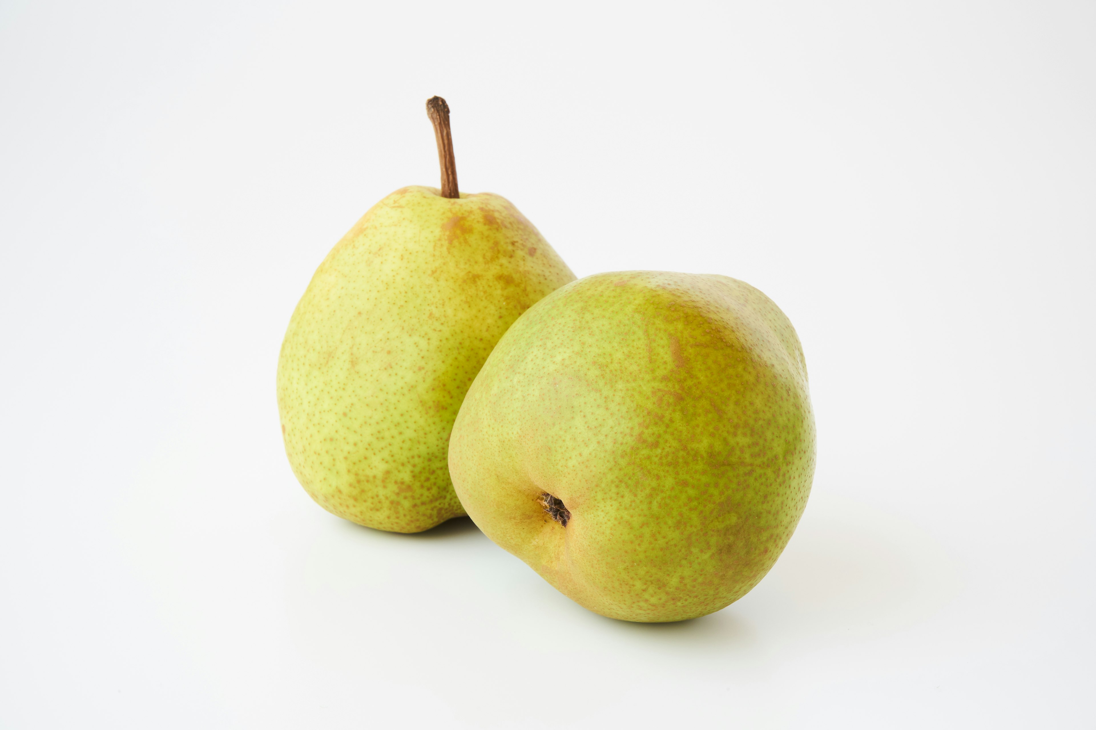 Two green pears placed on a white background