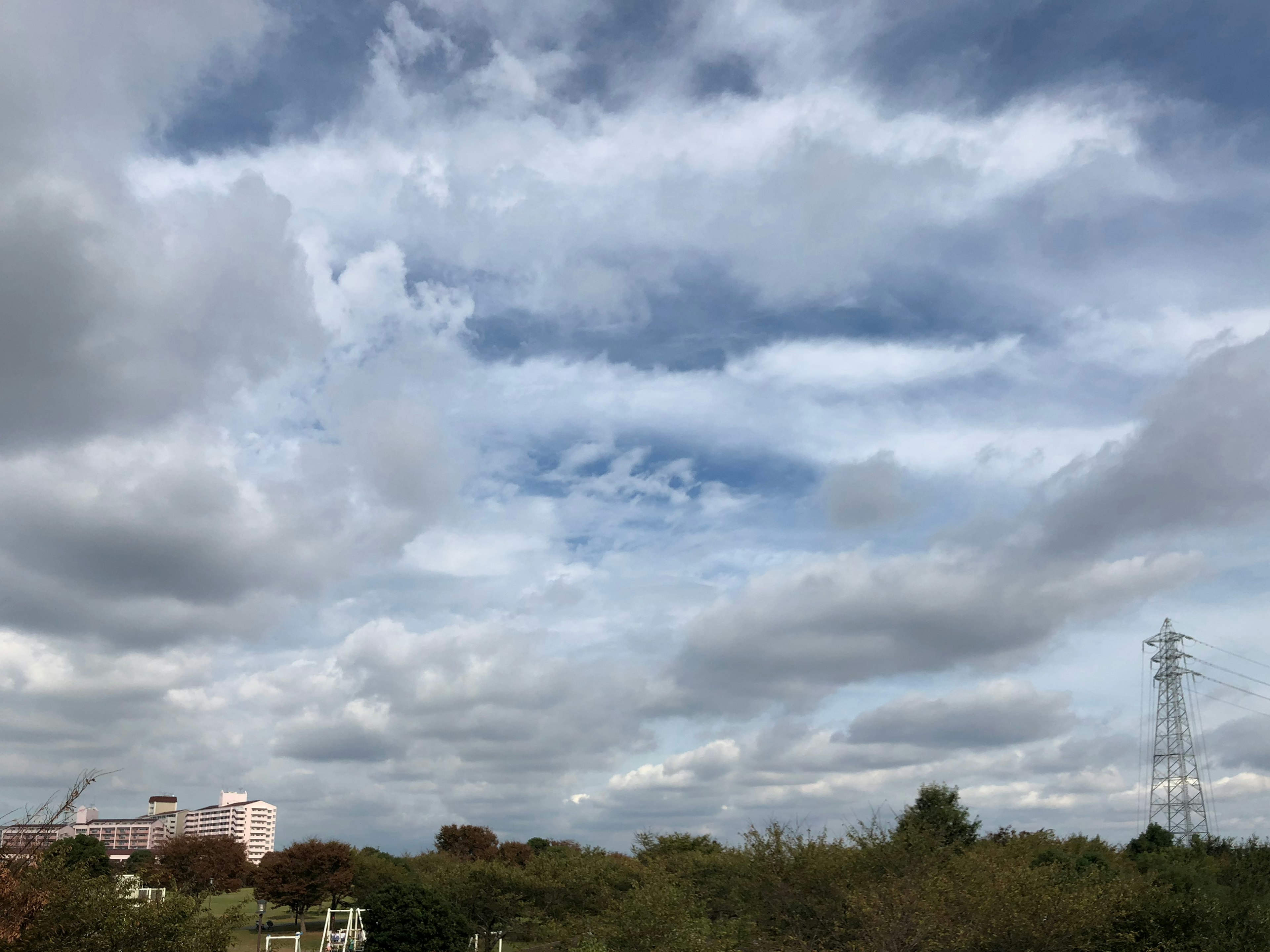 青空の雲と高い電柱が見える風景