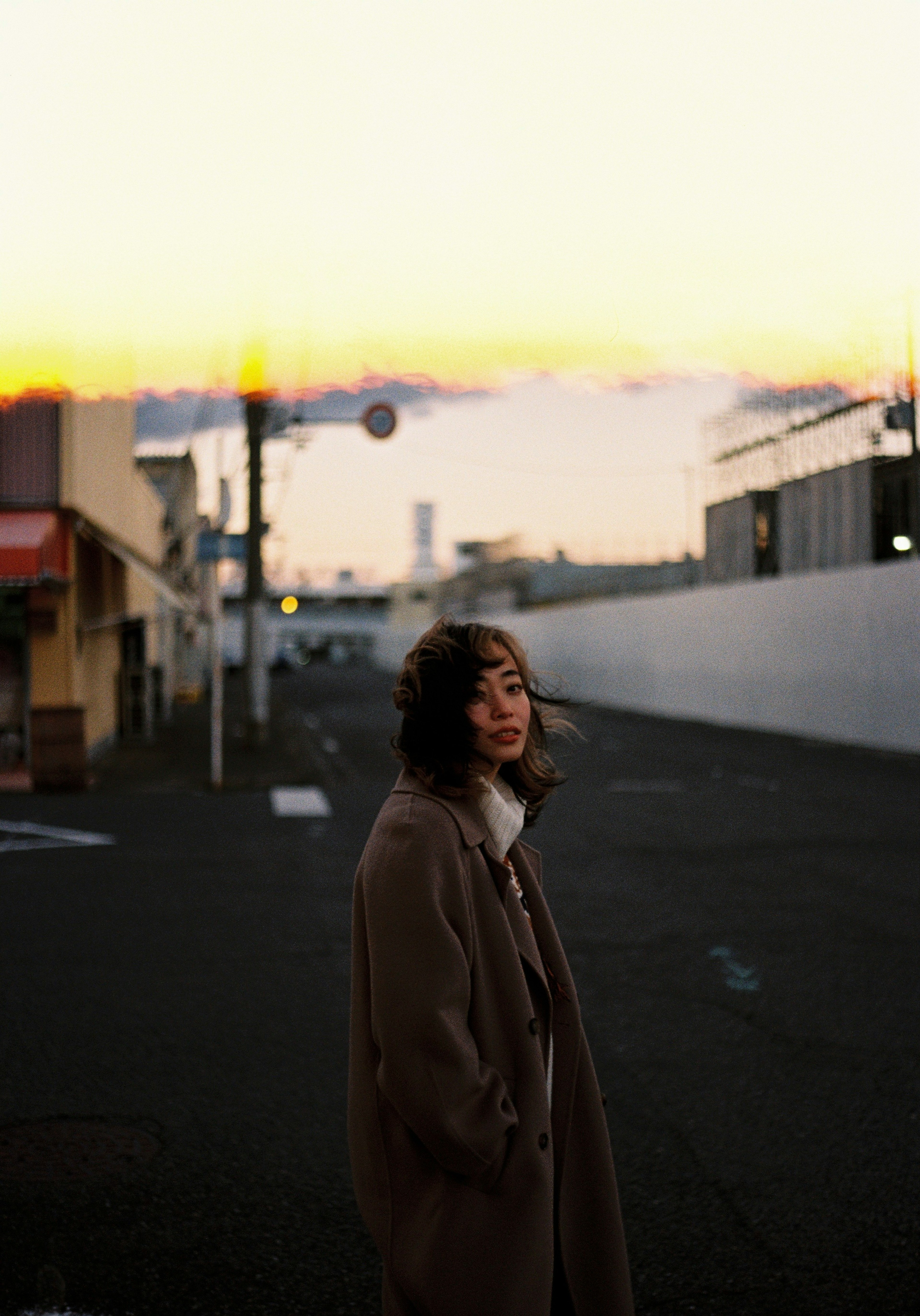 A woman smiling in a city street during sunset