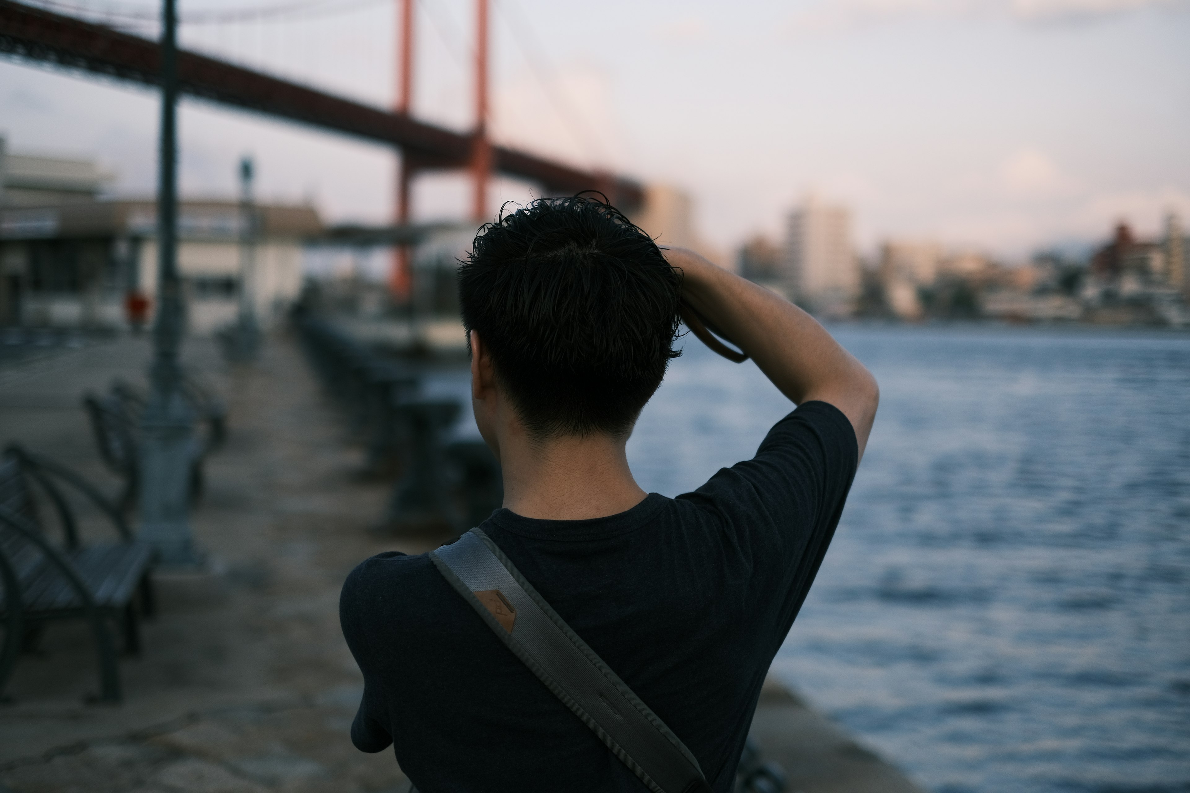 Person von hinten, die sich am Fluss die Haare streichelt