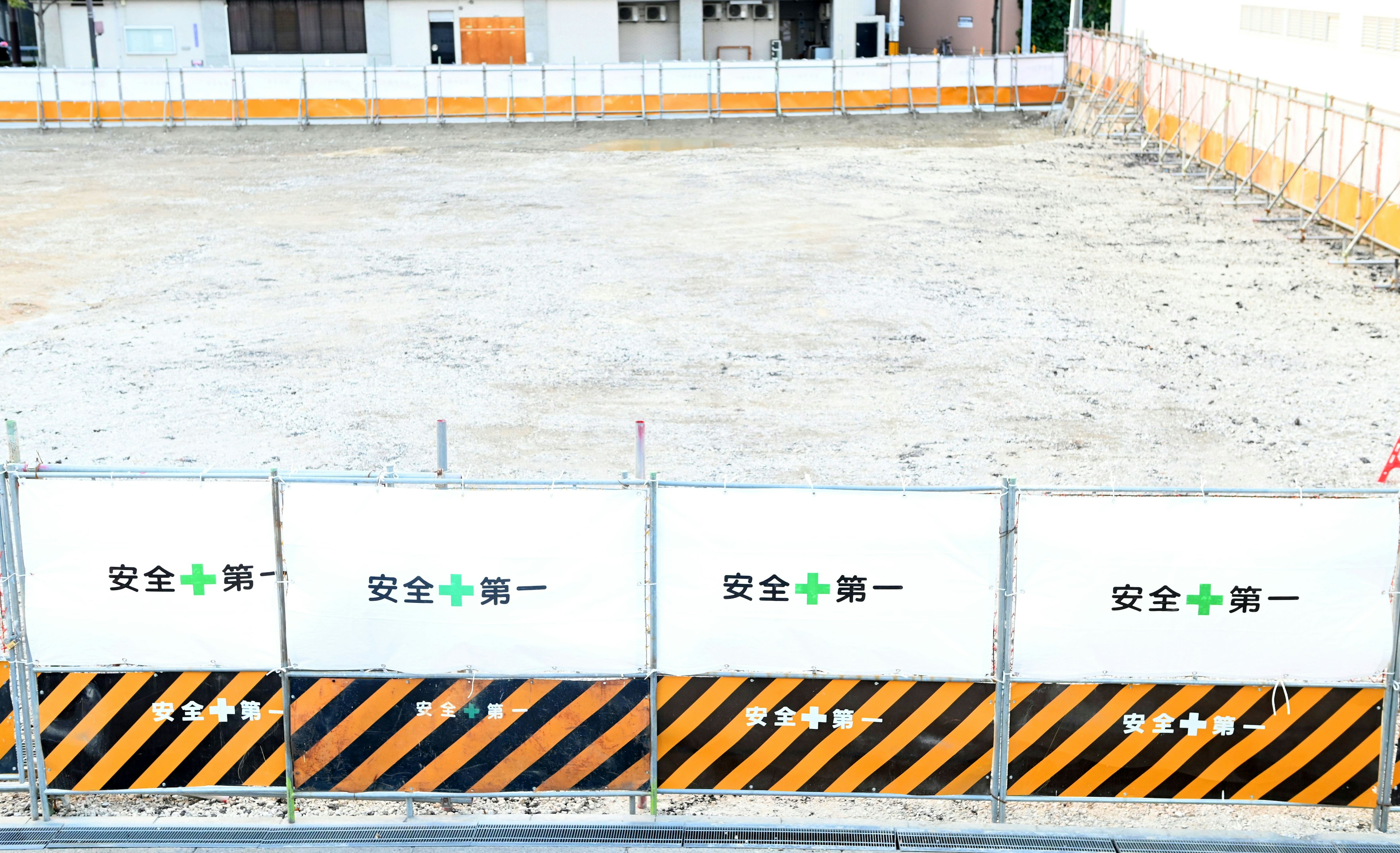 Leerer Bauplatz mit Sicherheitsbarrieren und Schildern