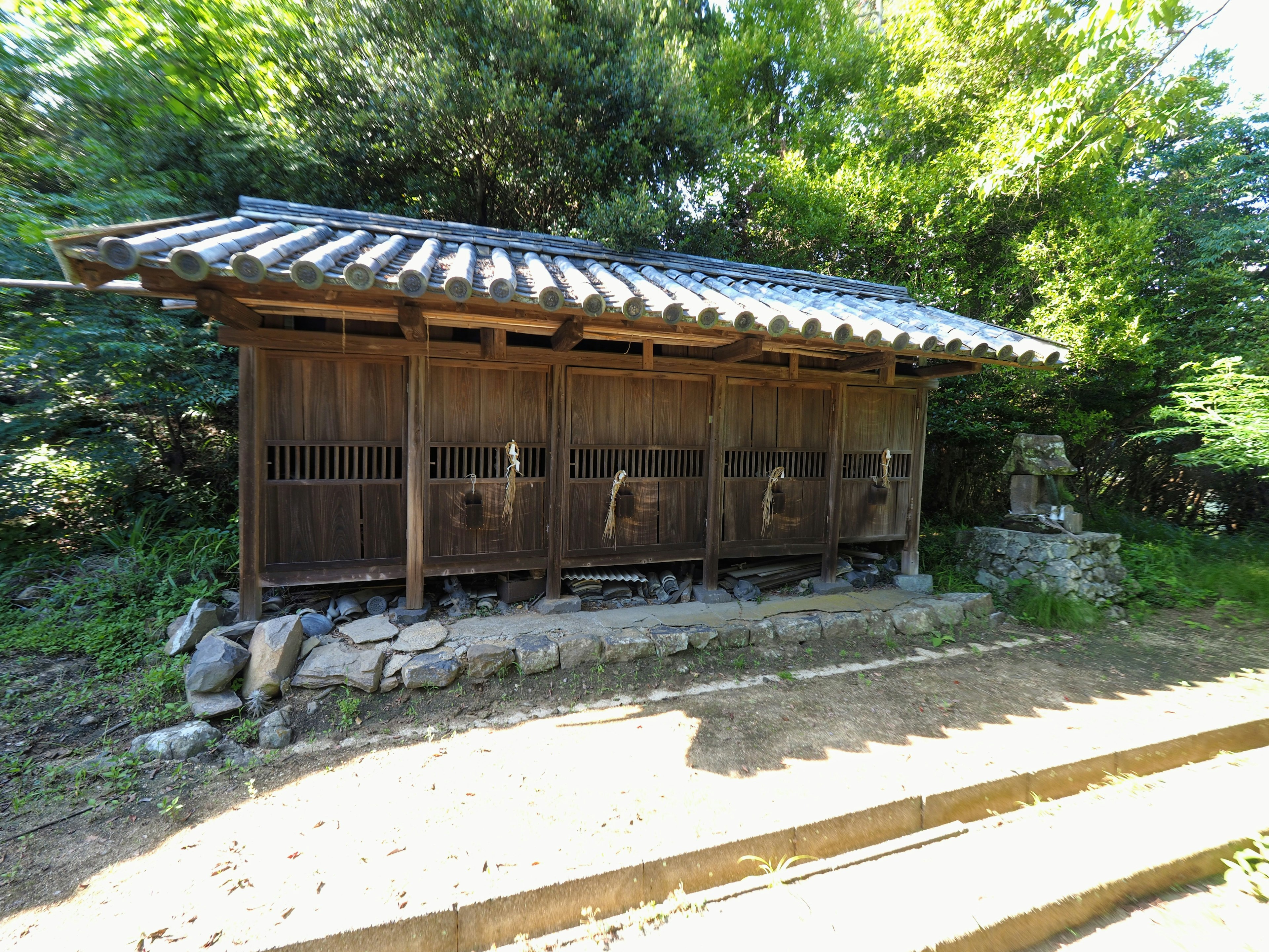 Traditional Japanese wooden toilet building surrounded by greenery