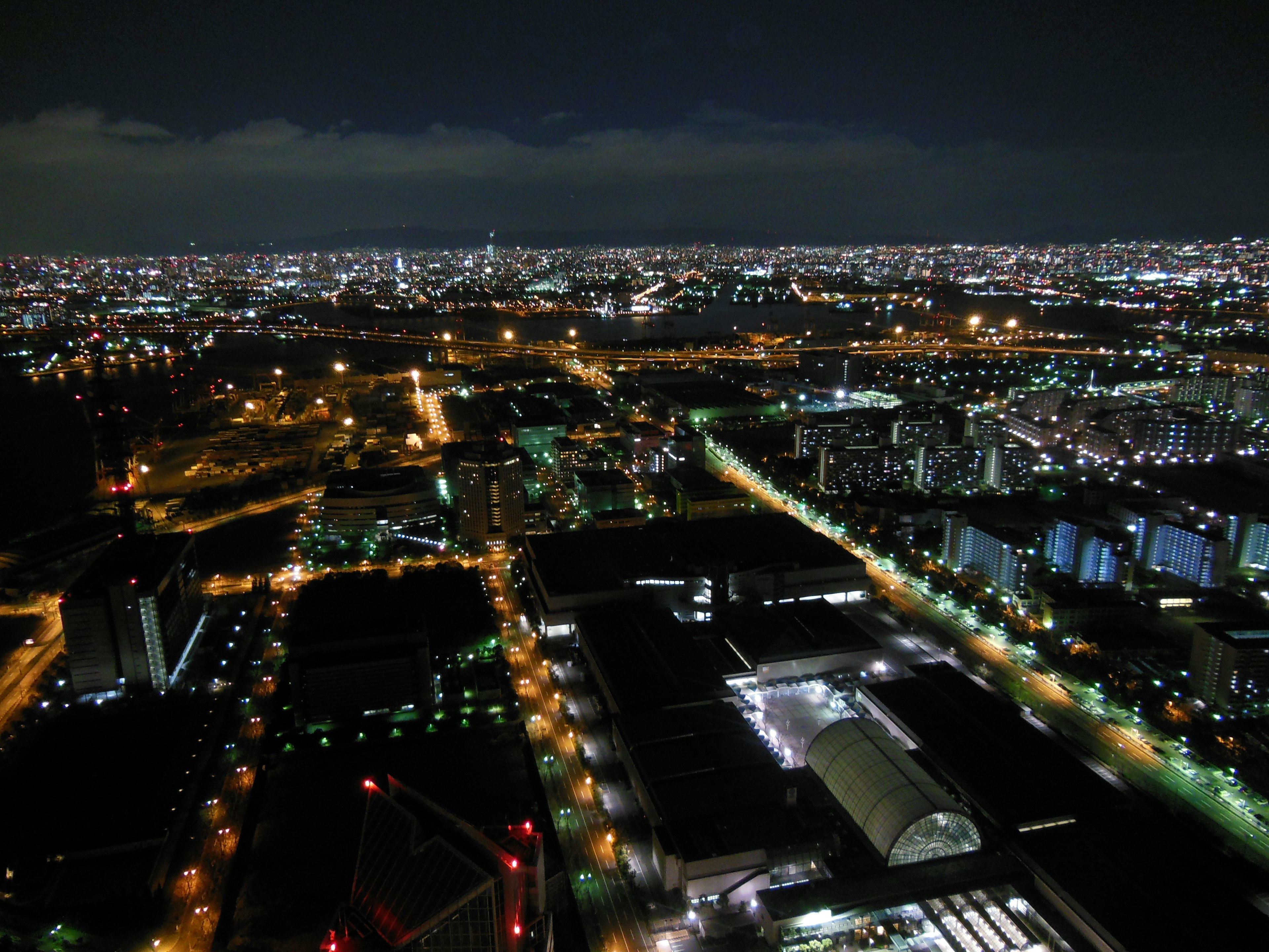 Vista notturna di un skyline urbano con edifici illuminati e luci stradali