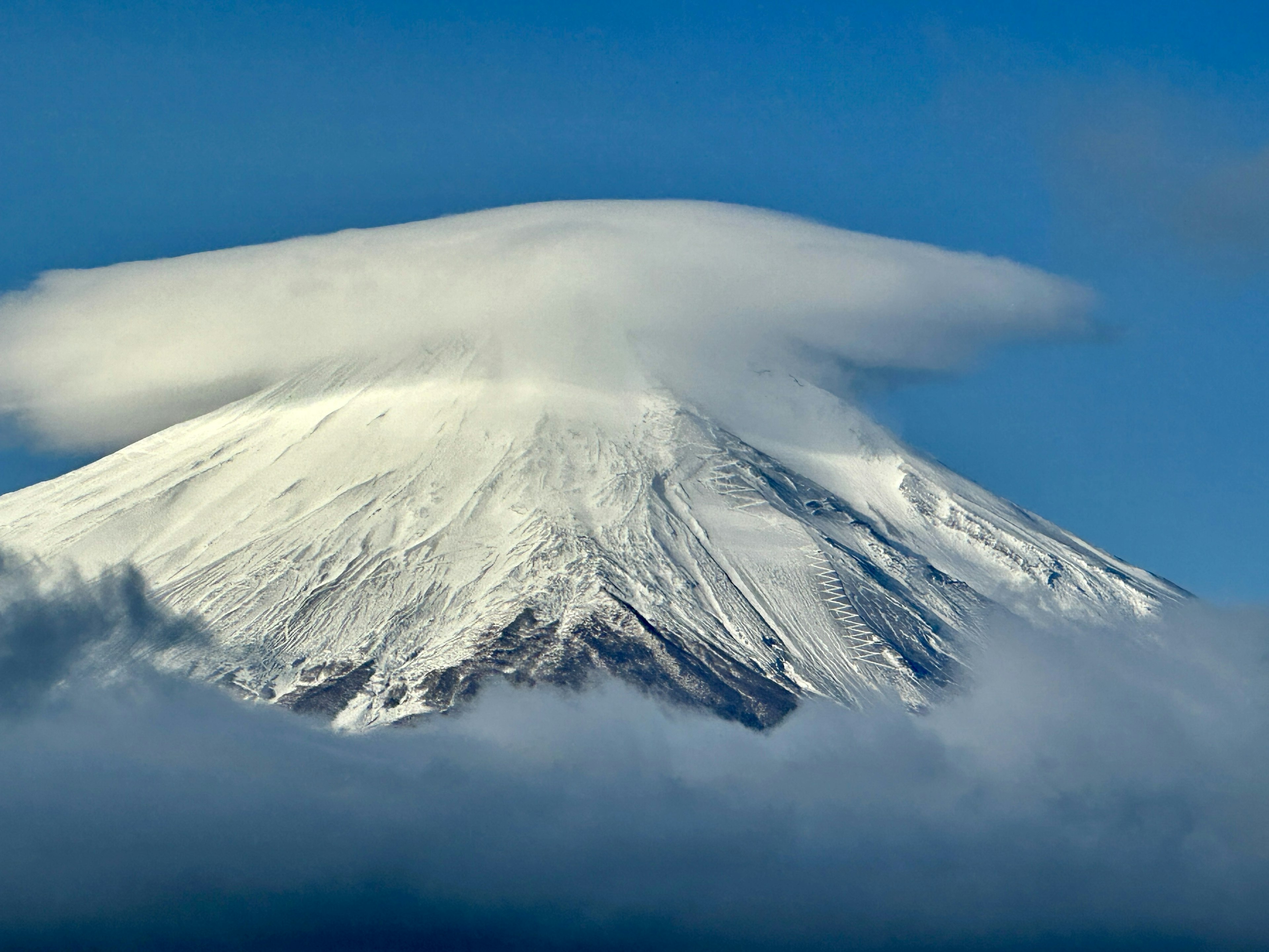 被雪覆蓋的富士山頂上有一層雲帽