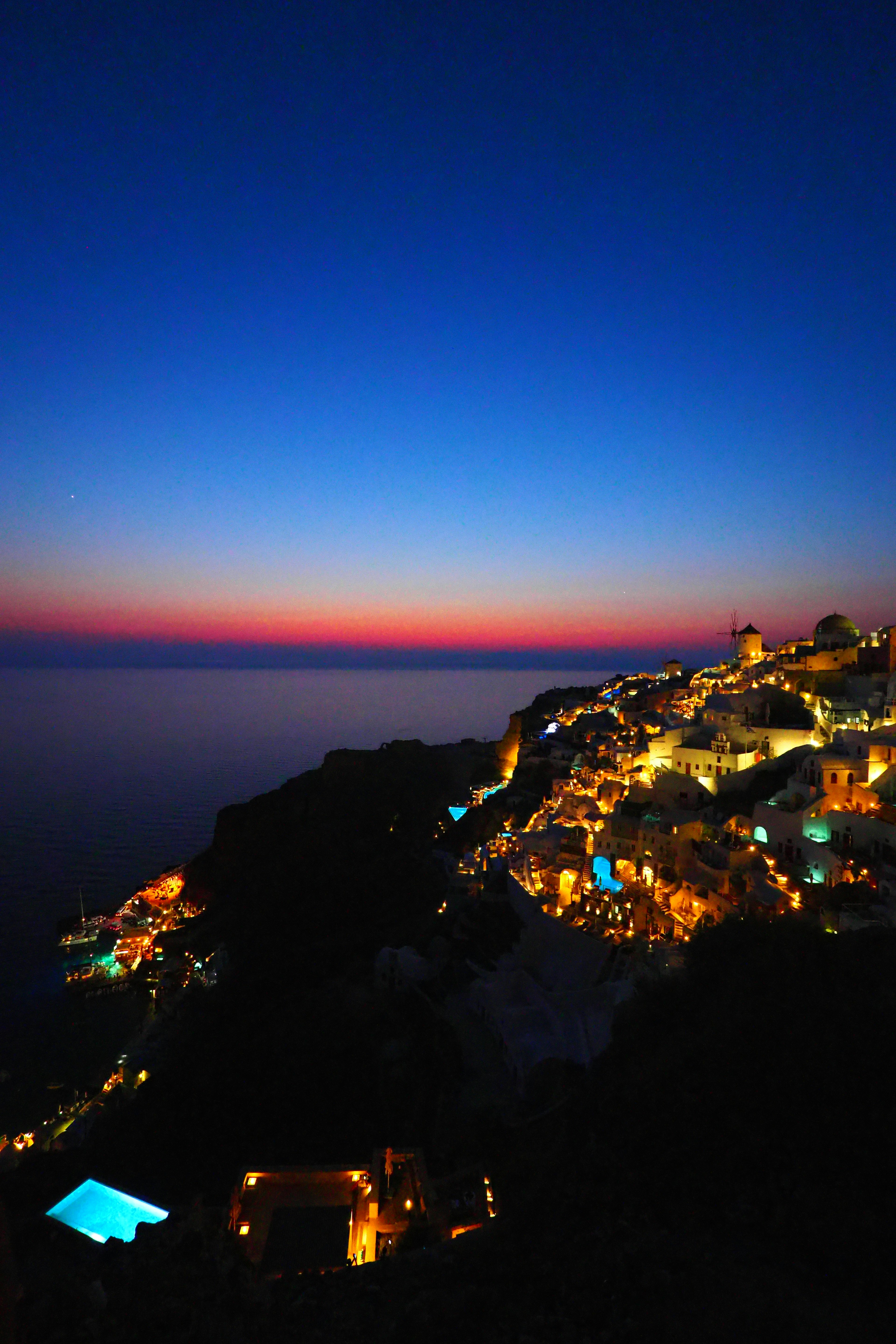 Beautiful coastal sunset with bright town lights