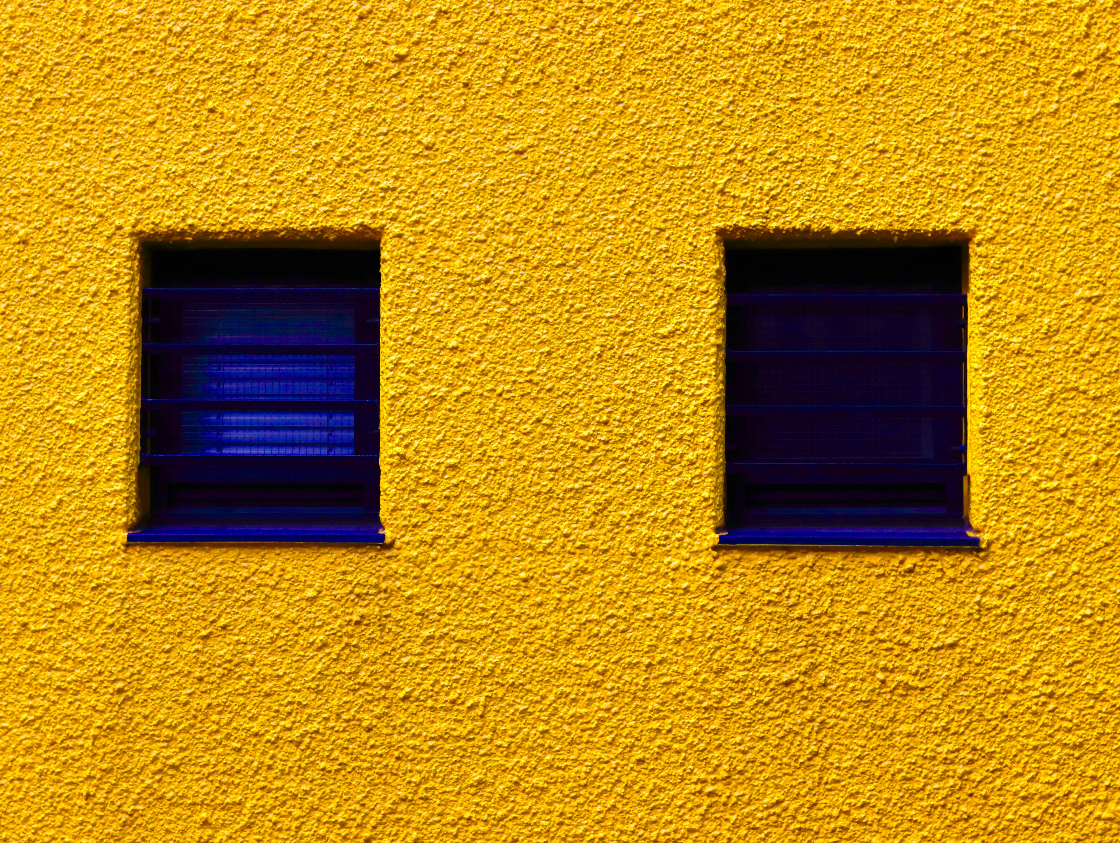 Simple design featuring two blue windows on a yellow wall