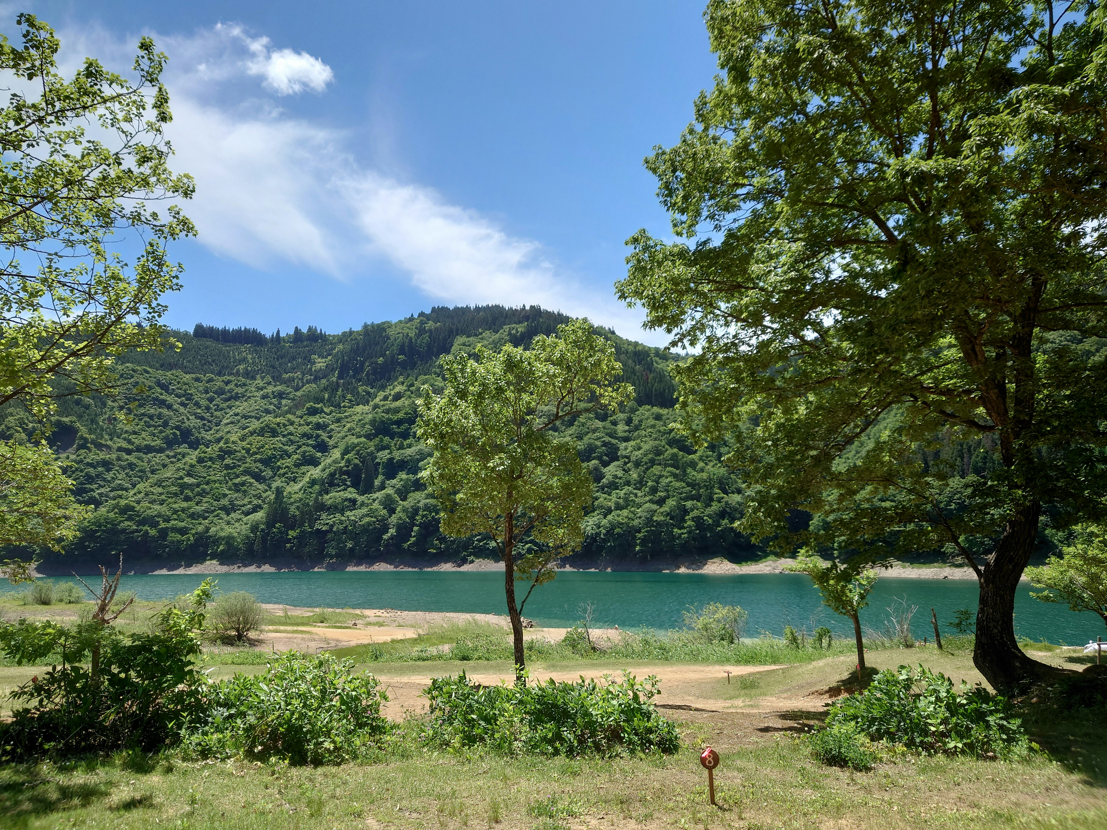 Vista escénica de un lago azul rodeado de montañas verdes