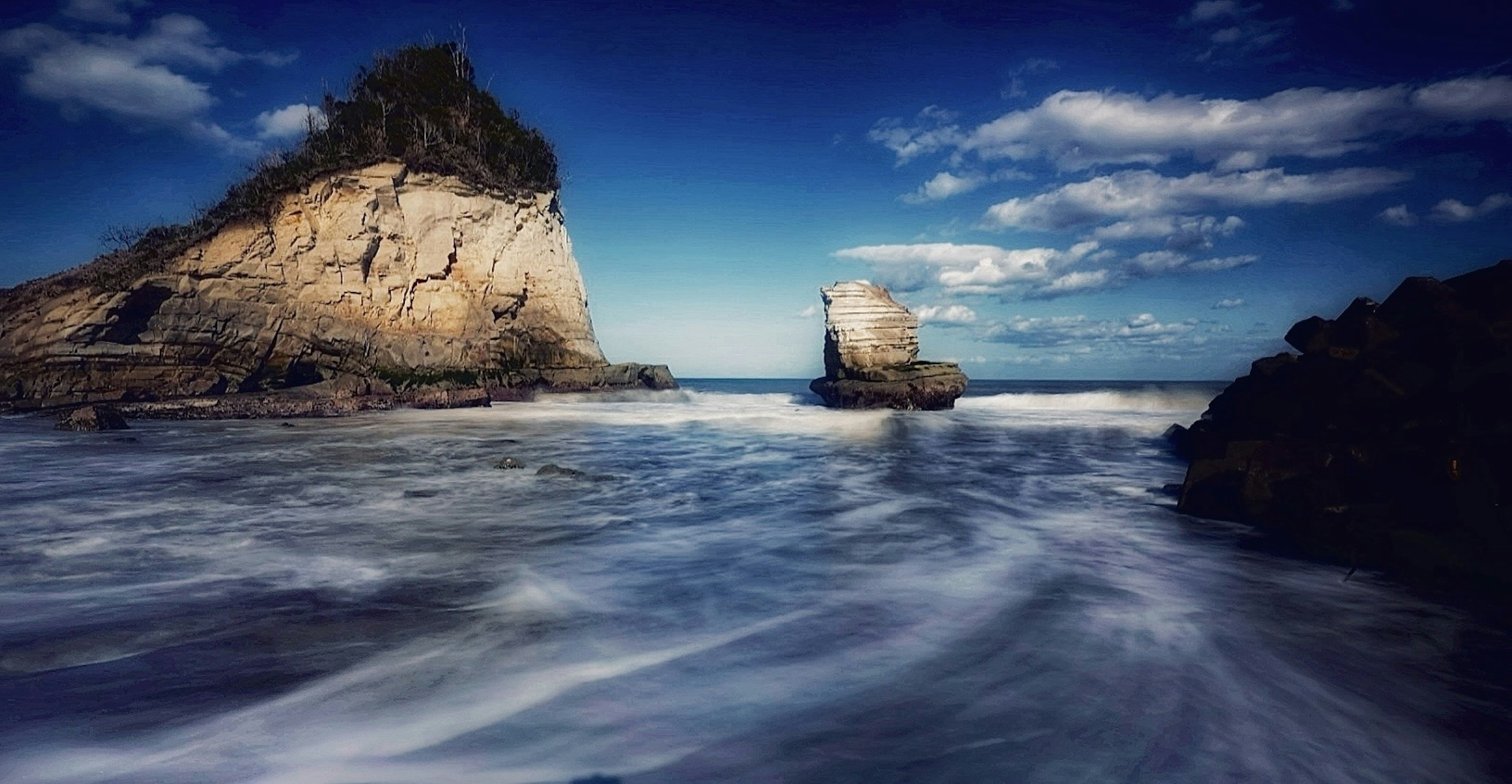 Beautiful coastal scene with gentle waves crashing against rocks