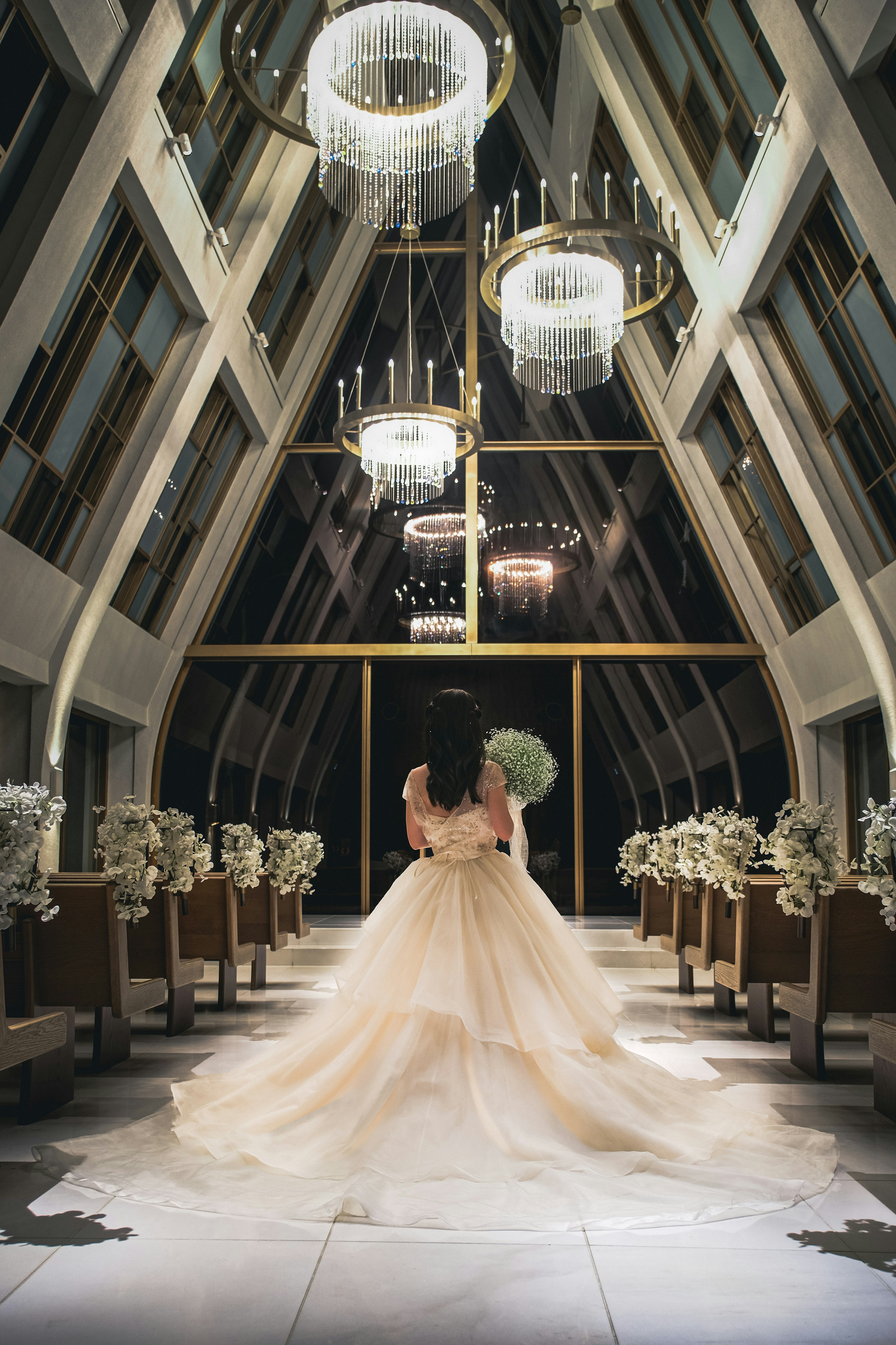 Novia en un hermoso vestido de boda mirando hacia atrás dentro de una capilla lujosa