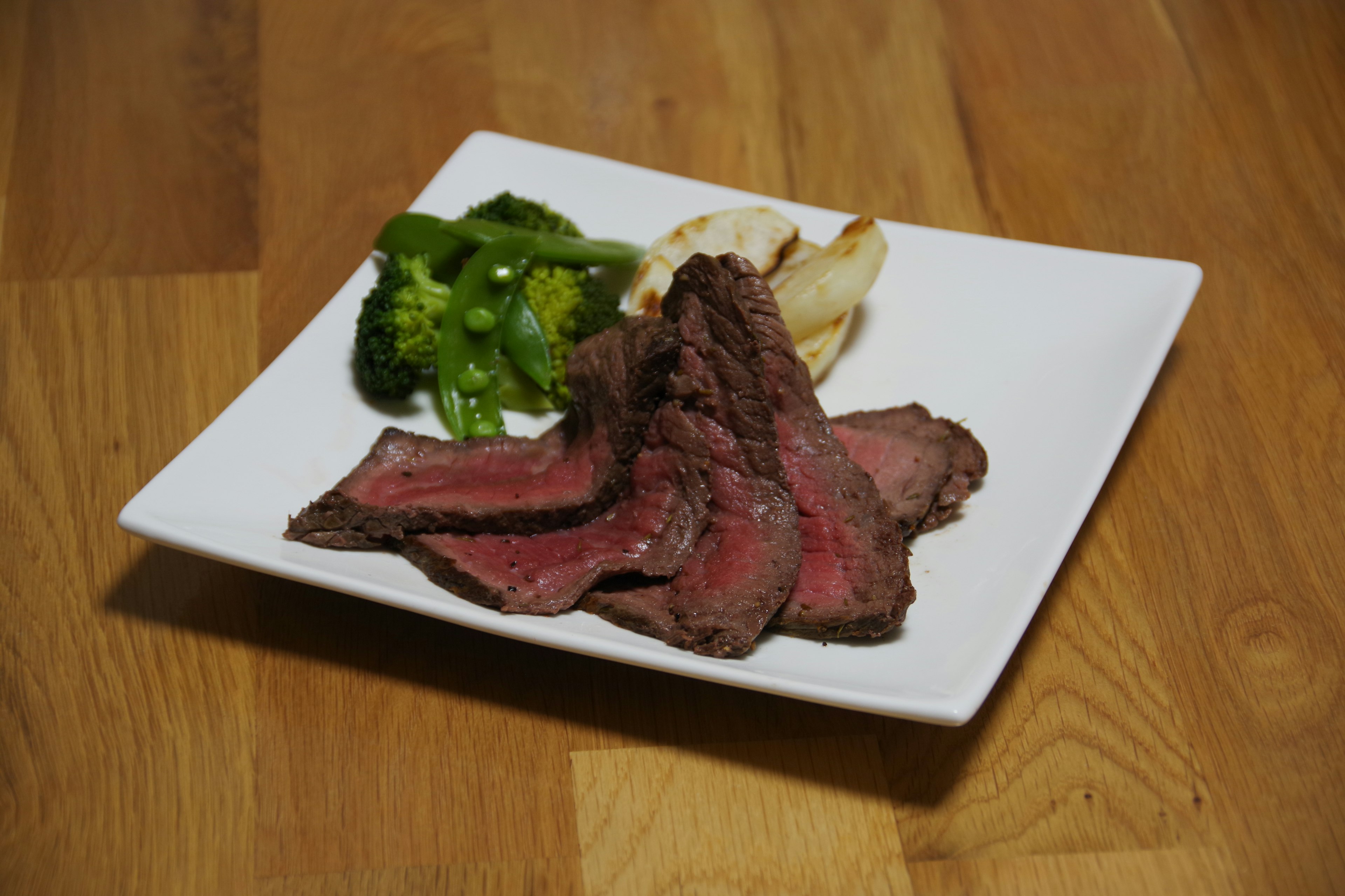 Plated dish featuring sliced beef with broccoli and potatoes