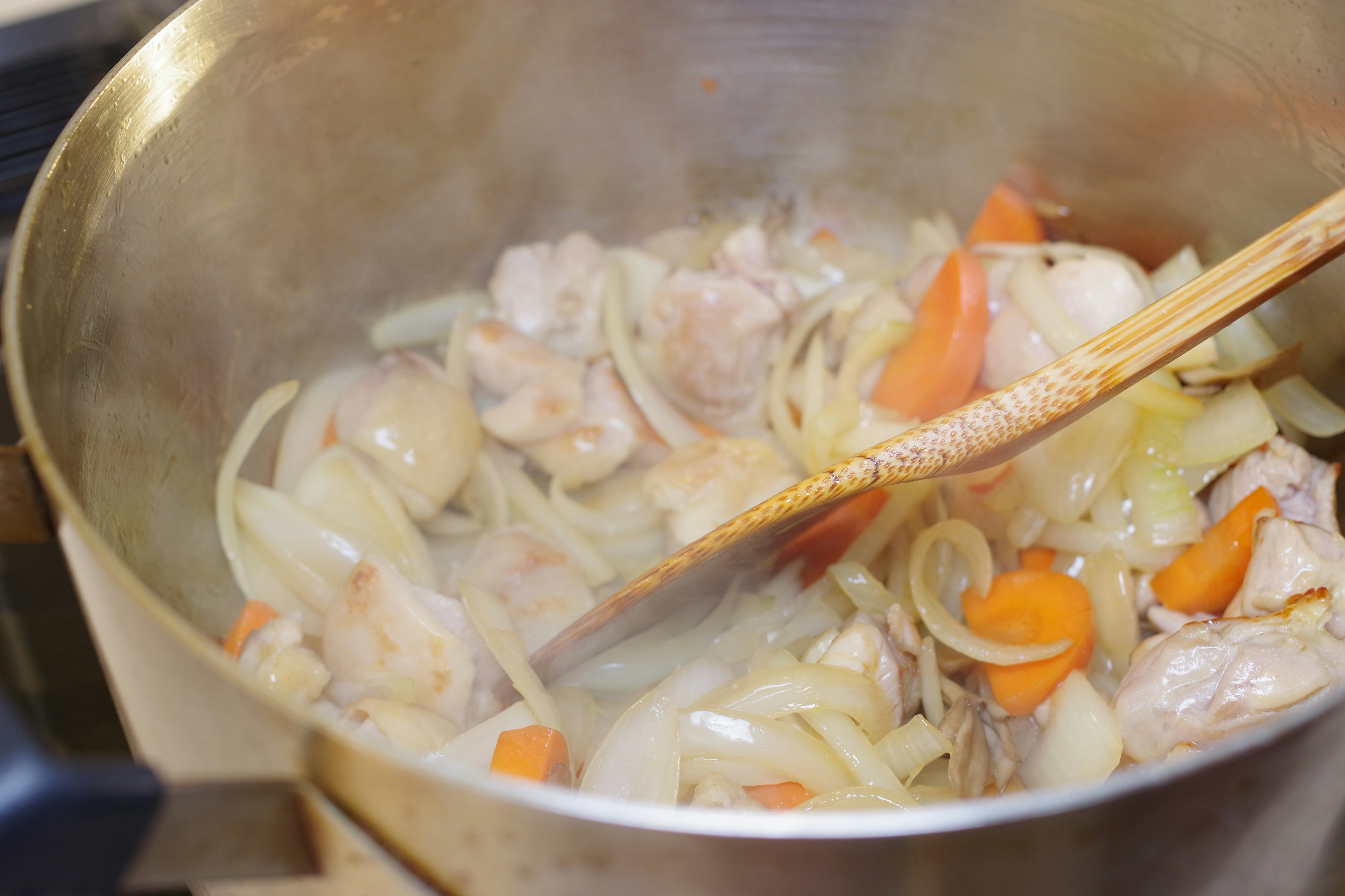 Dampfender Topf mit Hähnchen und Gemüse, das gekocht wird