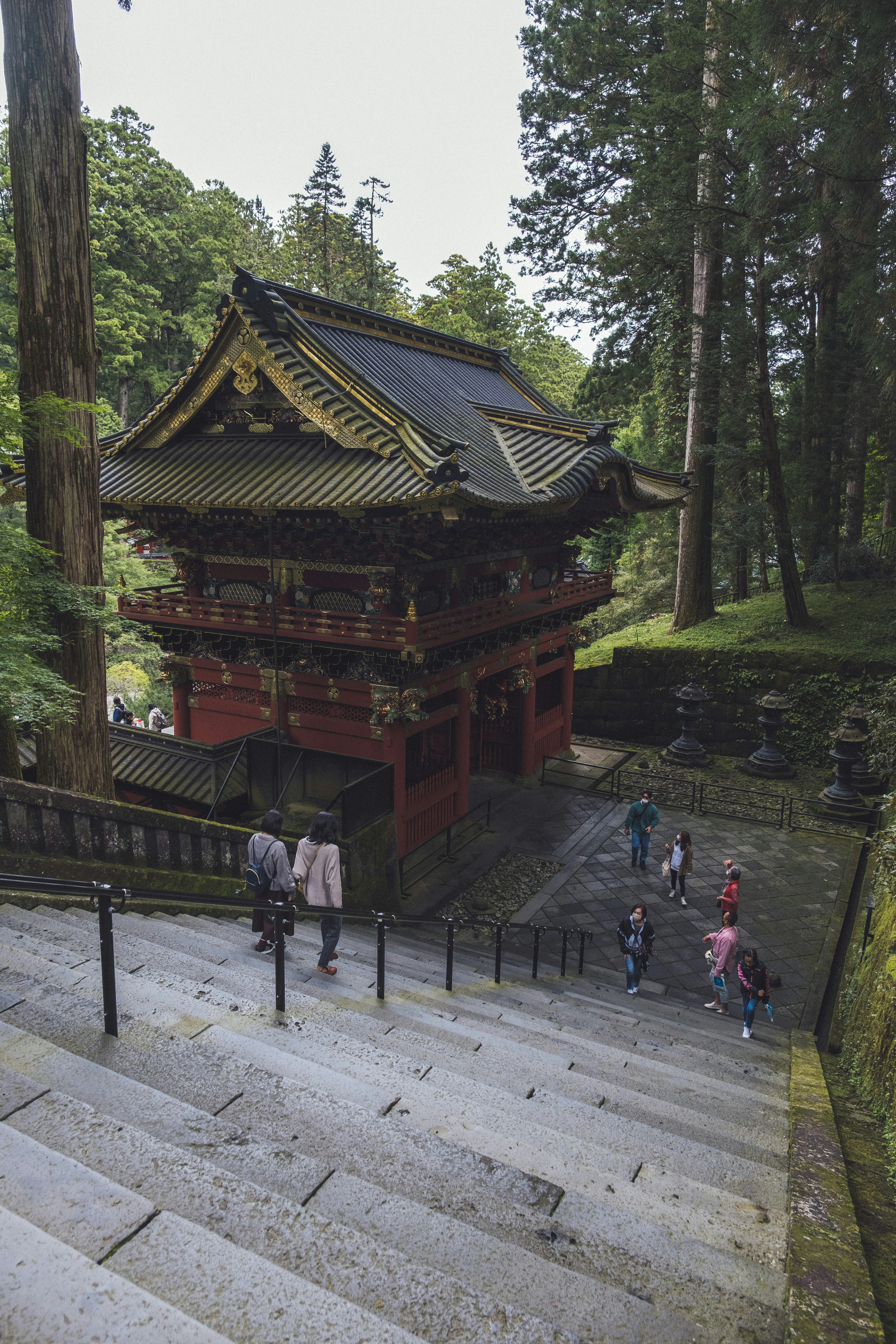 美しい神社の建物が見える階段を下る人々